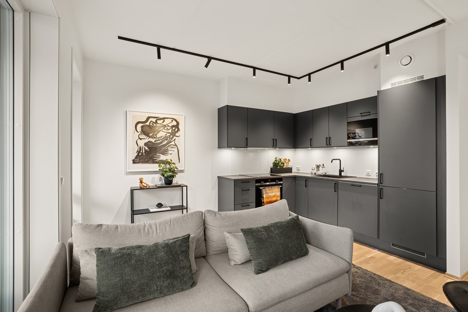 Stue og kjøkken ligger i åpen løsning. Et lyst og innbydende rom med store vindusflater som gir rikelig med naturlig lys. Galleribilde