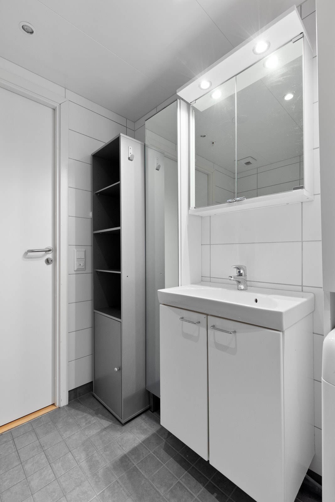 Badet inneholder veggmontert wc, dusjhjørne, servant og speil. Galleribilde