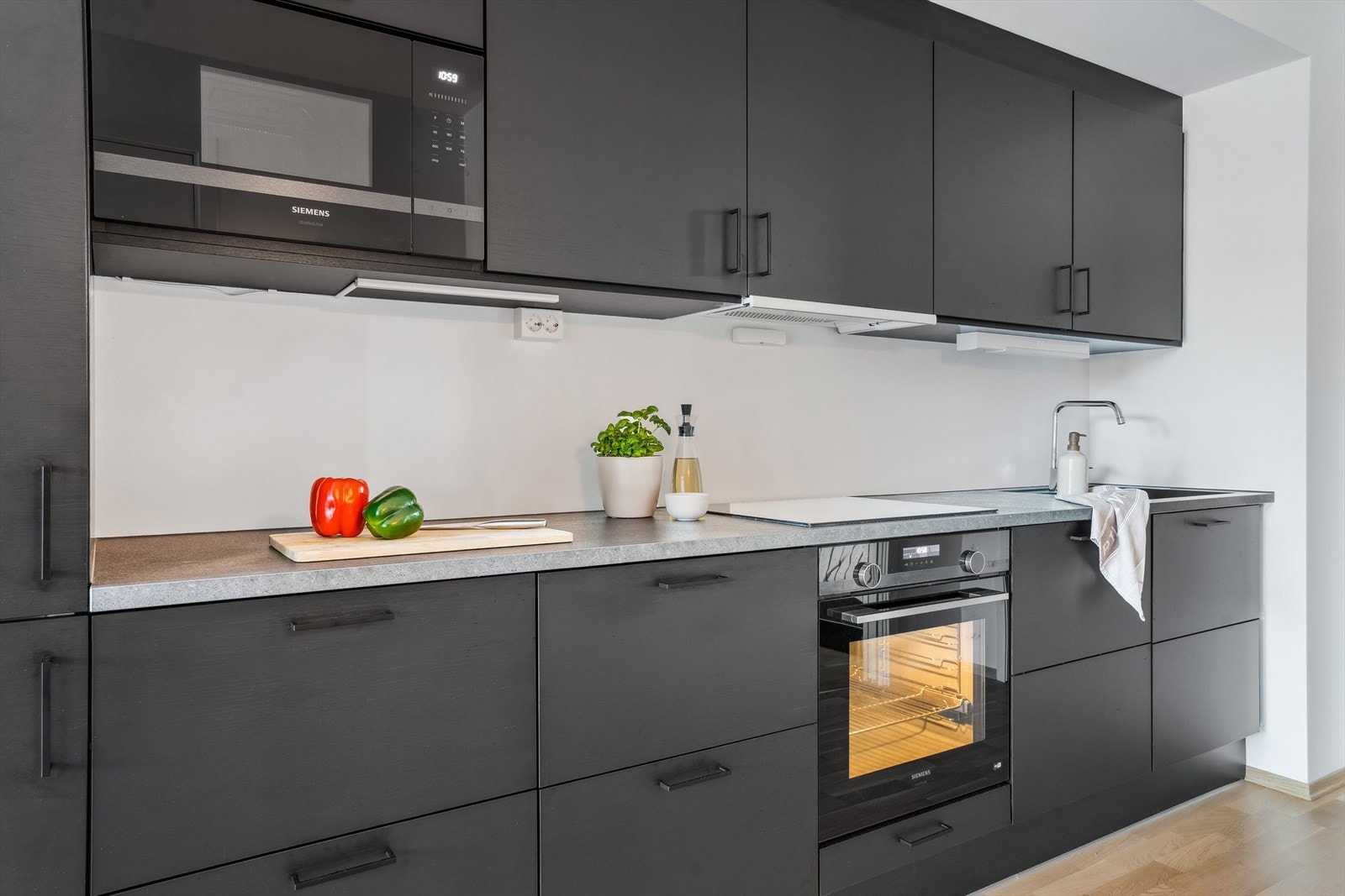 Alle hvitevarene er integrert; platetopp, stekeovn, oppvaskmaskin, mikrobølgeovn og en kombinert kjøl/frys. Galleribilde