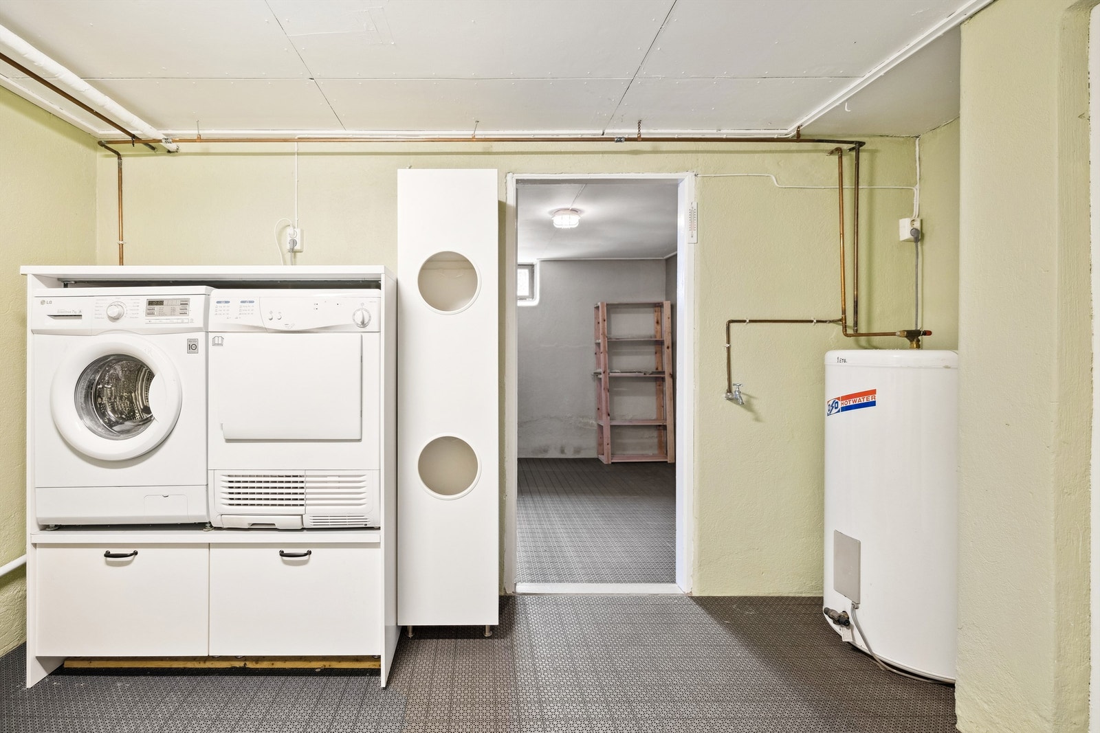 Felles vaskerom i kjelleren for begge boenhetene. Hver bolig har egen vaskemaskin og varmtvannstank. Galleribilde