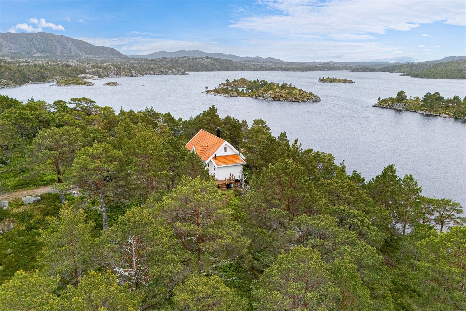 Flyfoto av nærområdet med oversikt over tomten, strandlinje og felles bryggeanlegg. Området byr på idyllisk kystnatur og gode solforhold. Galleribilde