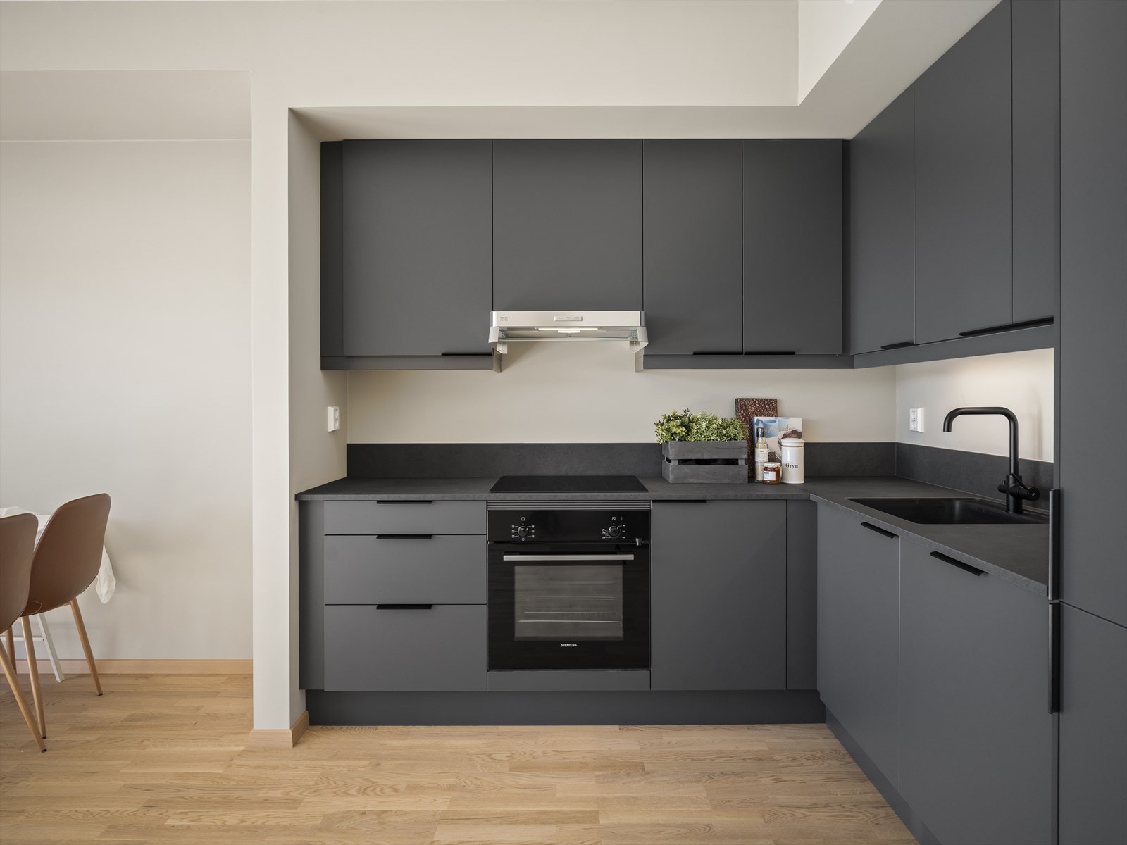 Kjøkkeninnredning med takhøye skap og integrerte hvitevarer Galleribilde