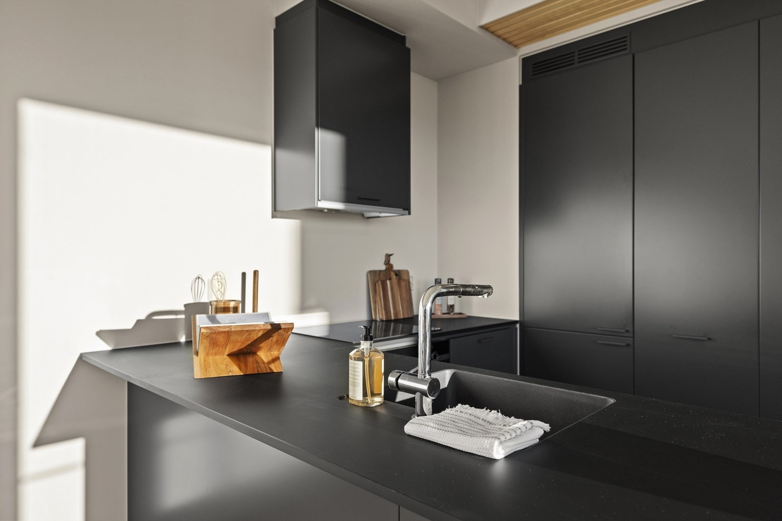 Benkeplaten er i sort laminat med nedfelt oppvaskkum. Galleribilde