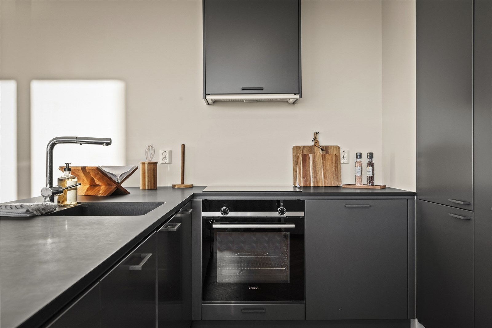 Integrerte hvitevarer fra Siemens bestående av kjøl/frys, oppvaskmaskin, induksjonstopp og stekeovn. Galleribilde