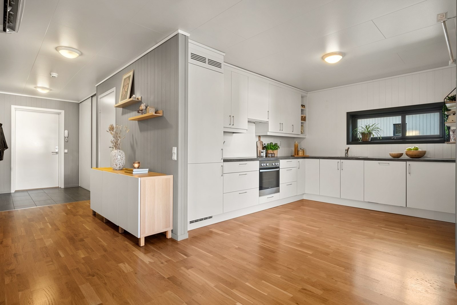 Det er integrert kjøl/fryseskap, stekovn, platetopp og oppvaskmaskin på kjøkken Galleribilde