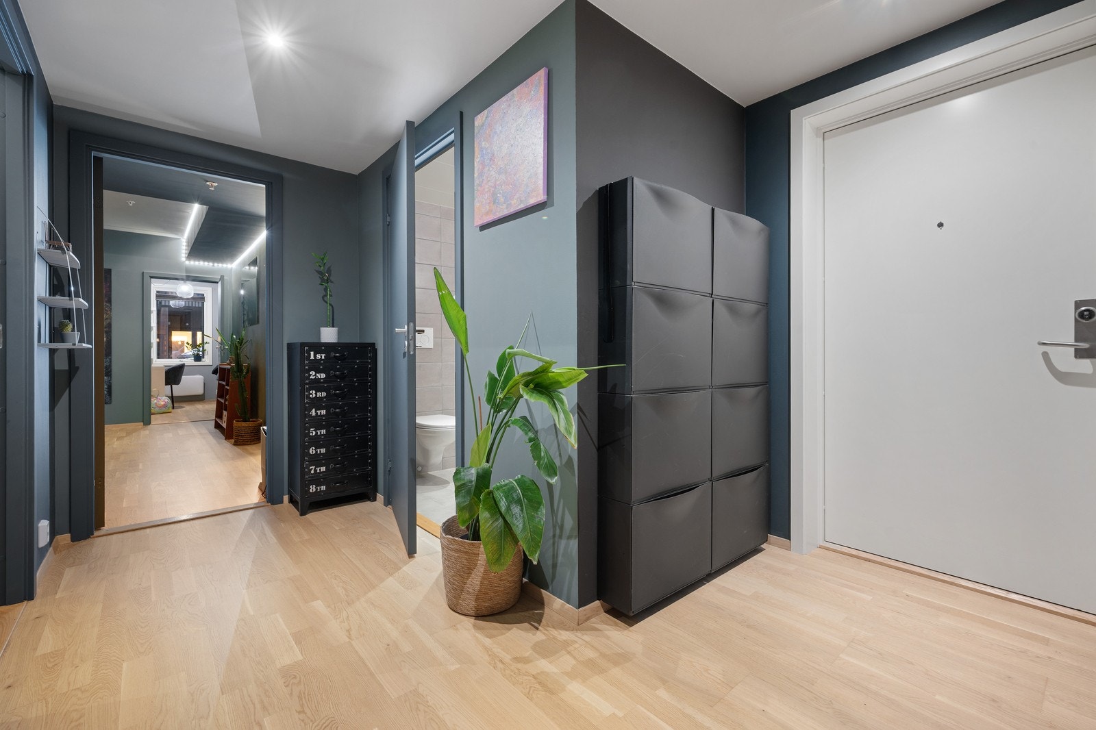 Lys eikeparkett og mørke vegger gir en varm og innbydende følelse i entréen. Galleribilde