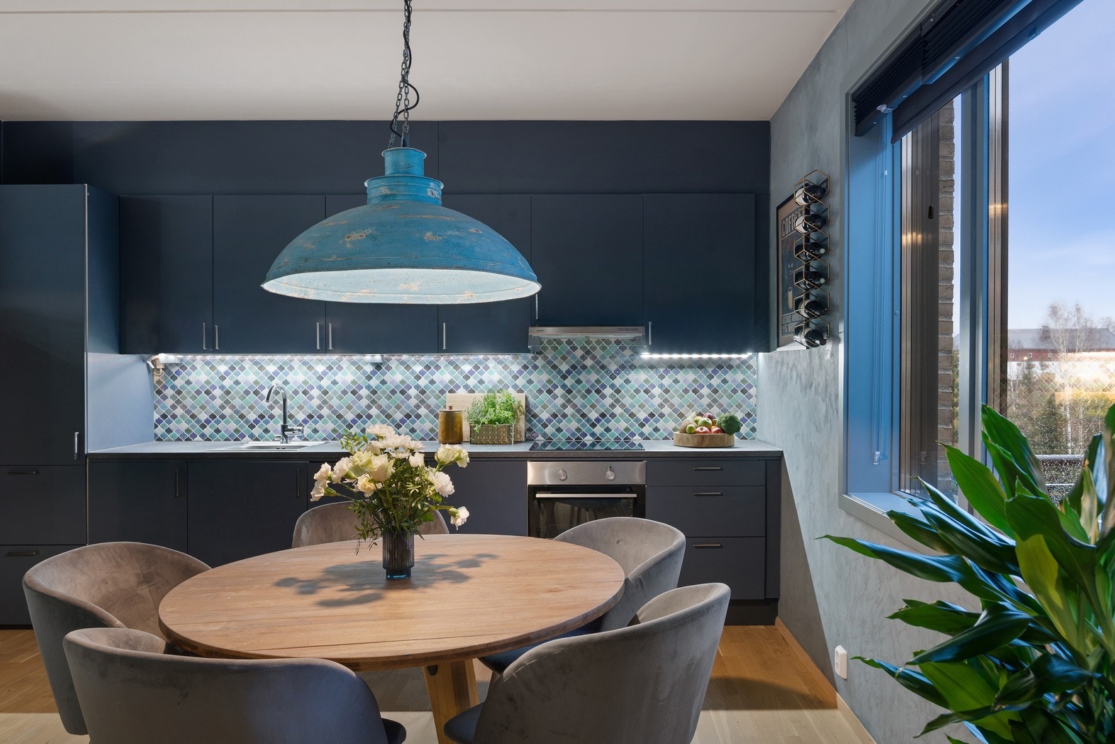 Malte slette fronter på kjøkkeninnredningen i samme fargepallett som resten av leiligheten, gir et ryddig og stilrent uttrykk. Galleribilde