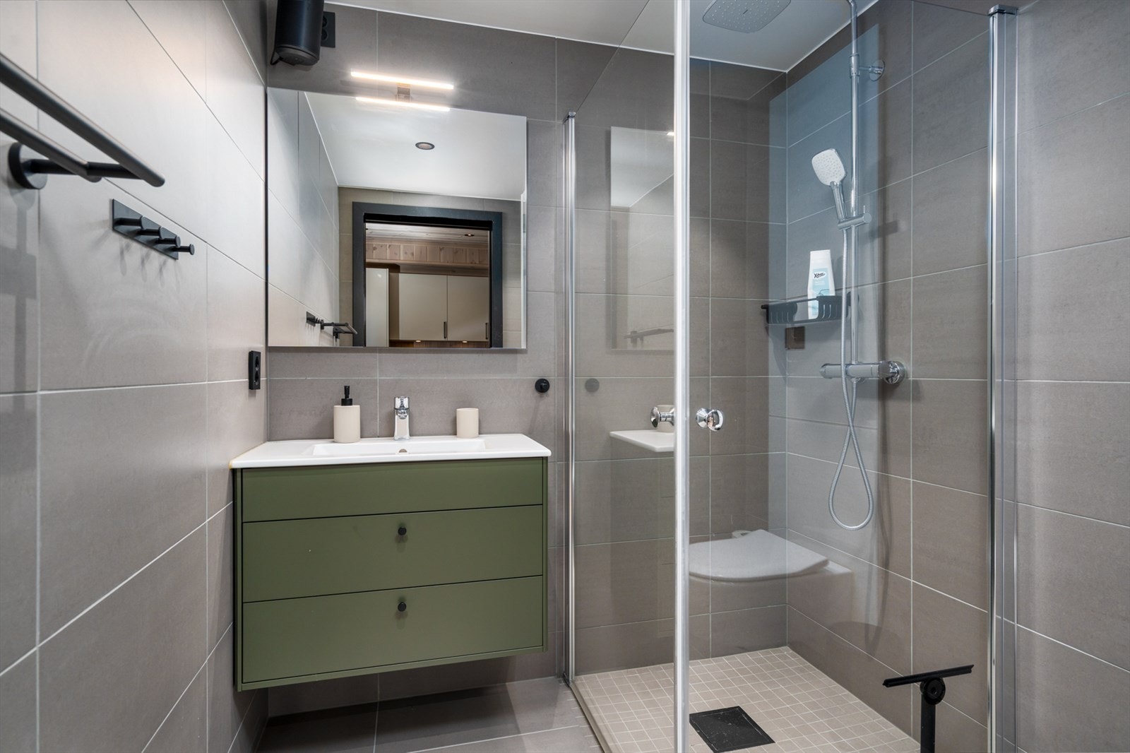 Flislagt bad med vegg hengt wc, dusj hjørne og baderoms innredning Galleribilde