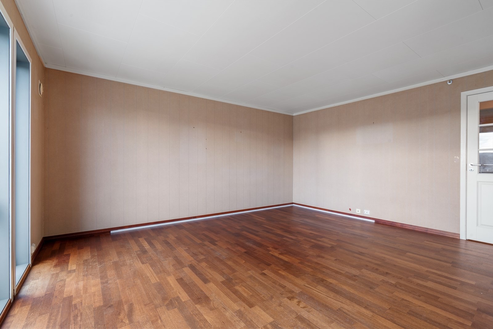 Stuen har parkett på gulv og tapetserte flater Galleribilde