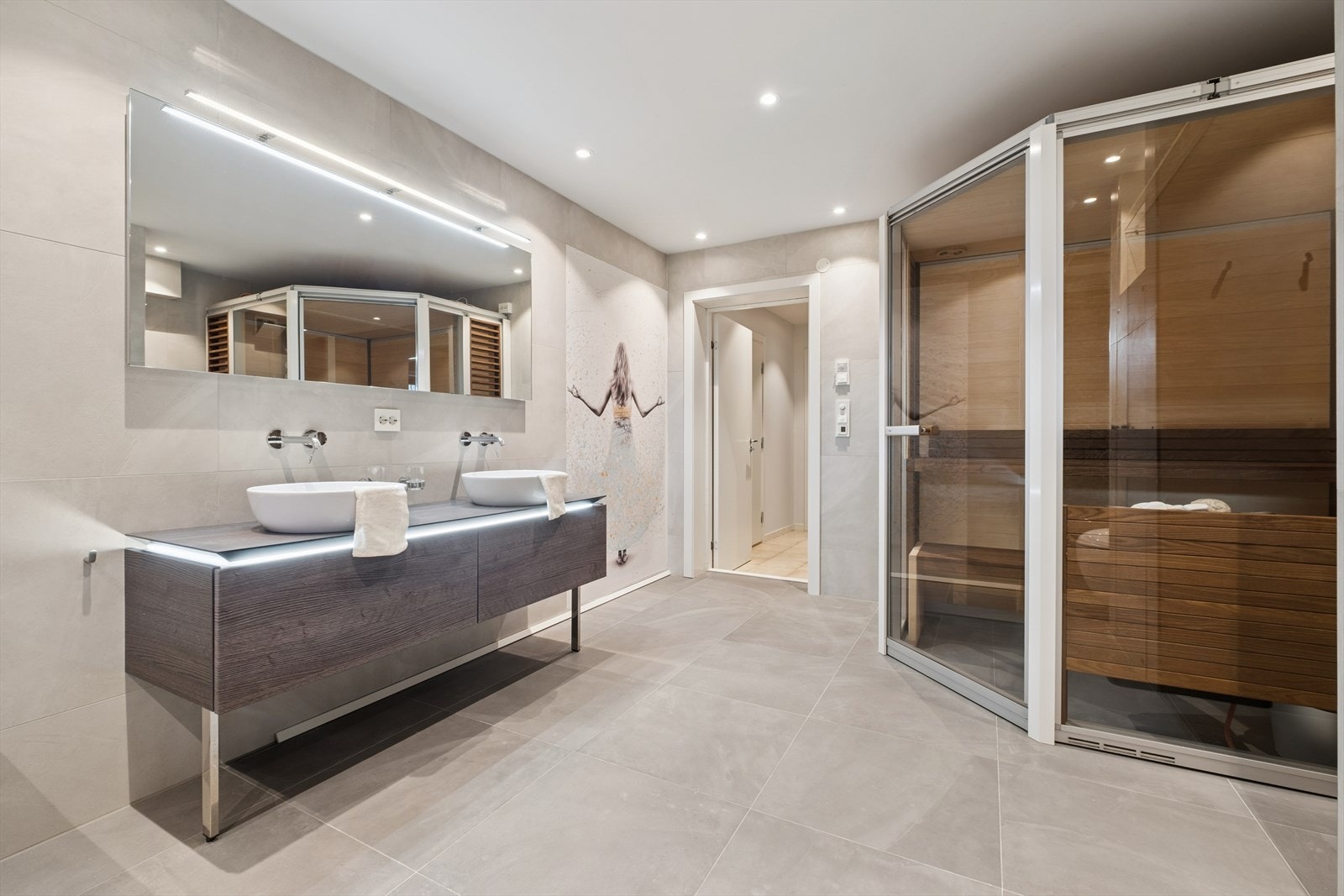 Badet er utstyrt med dobbel servantinnredning, badekar, dusjhjørne med glassvegger og toalett. Det er også en frittstående badstue her. Galleribilde