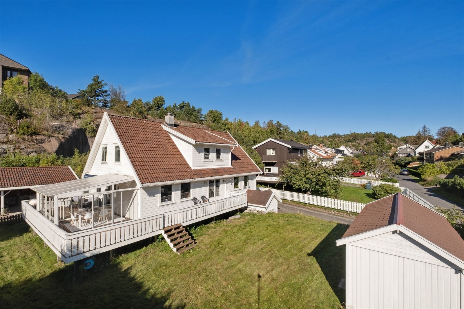 Tomten er lett skrående, opparbeidet med gressplen, hekk, busker og diverse beplantning. Galleribilde