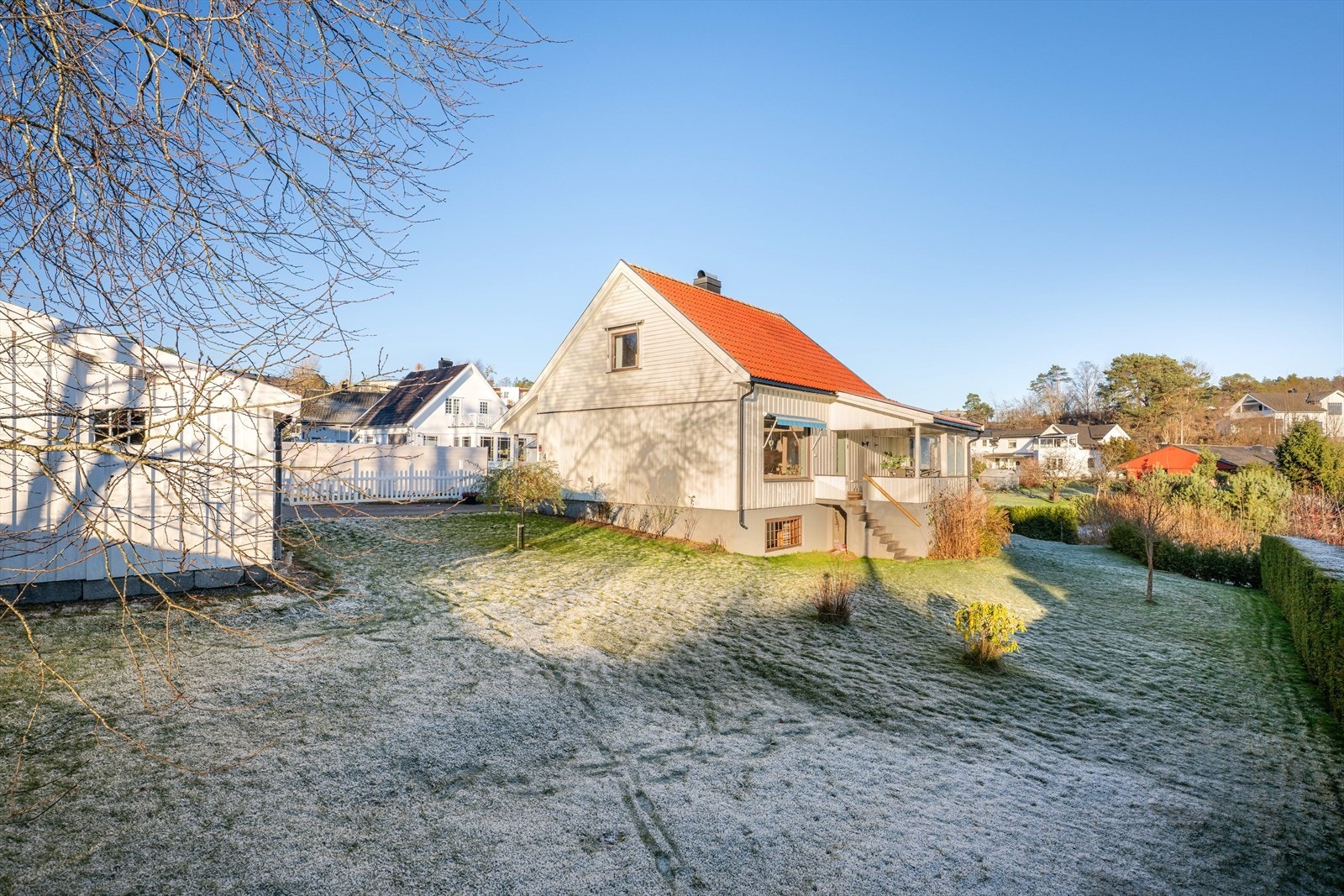 Tomta er pent innrammet med hekk og gjerde i størstedelen av tomtegrensa. Galleribilde