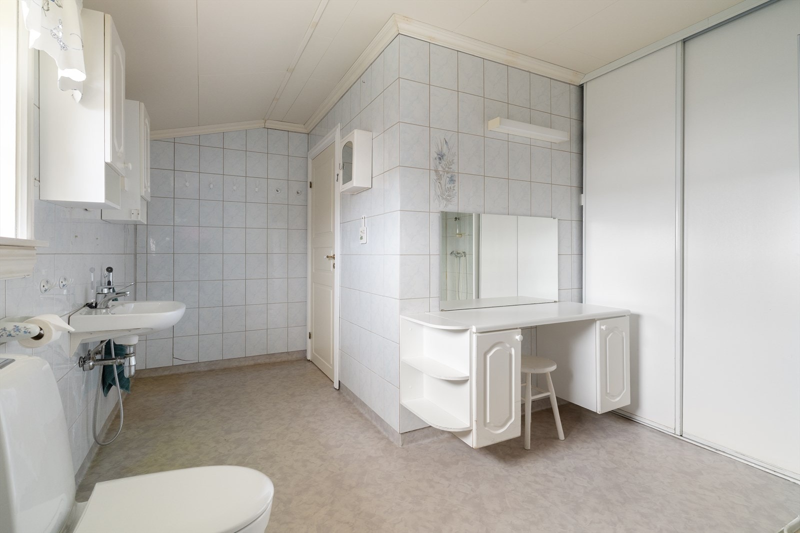 Badet fra 1992 er innredet med servant, benkeskap, dusjnisje med glassdører og toalett. Galleribilde