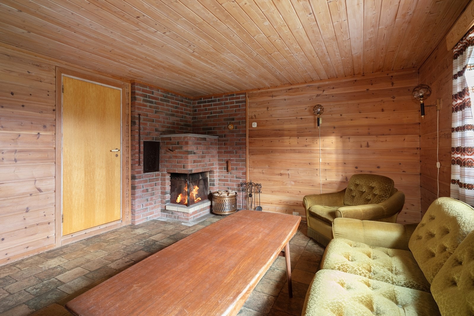 Kjellerstua har en stemningsfull åpen peis i det ene hjørnet. Galleribilde