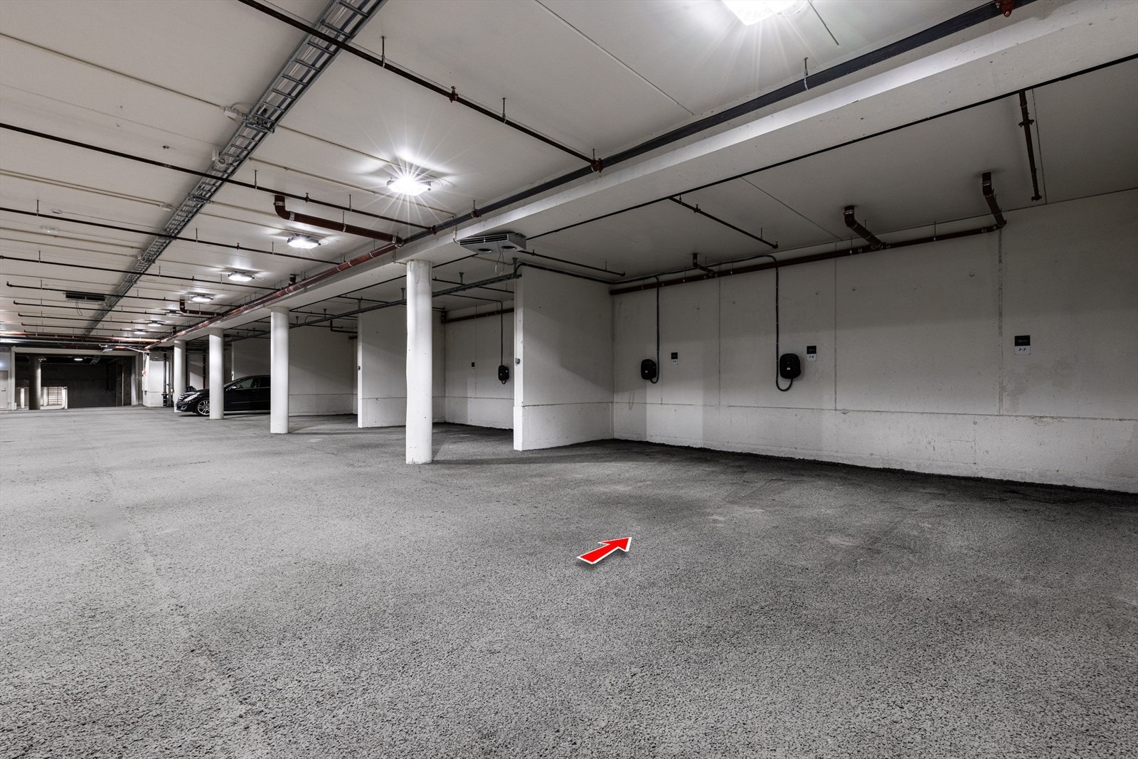 Parkeringsplass i garasjeanlegg med elbil-lader. Galleribilde