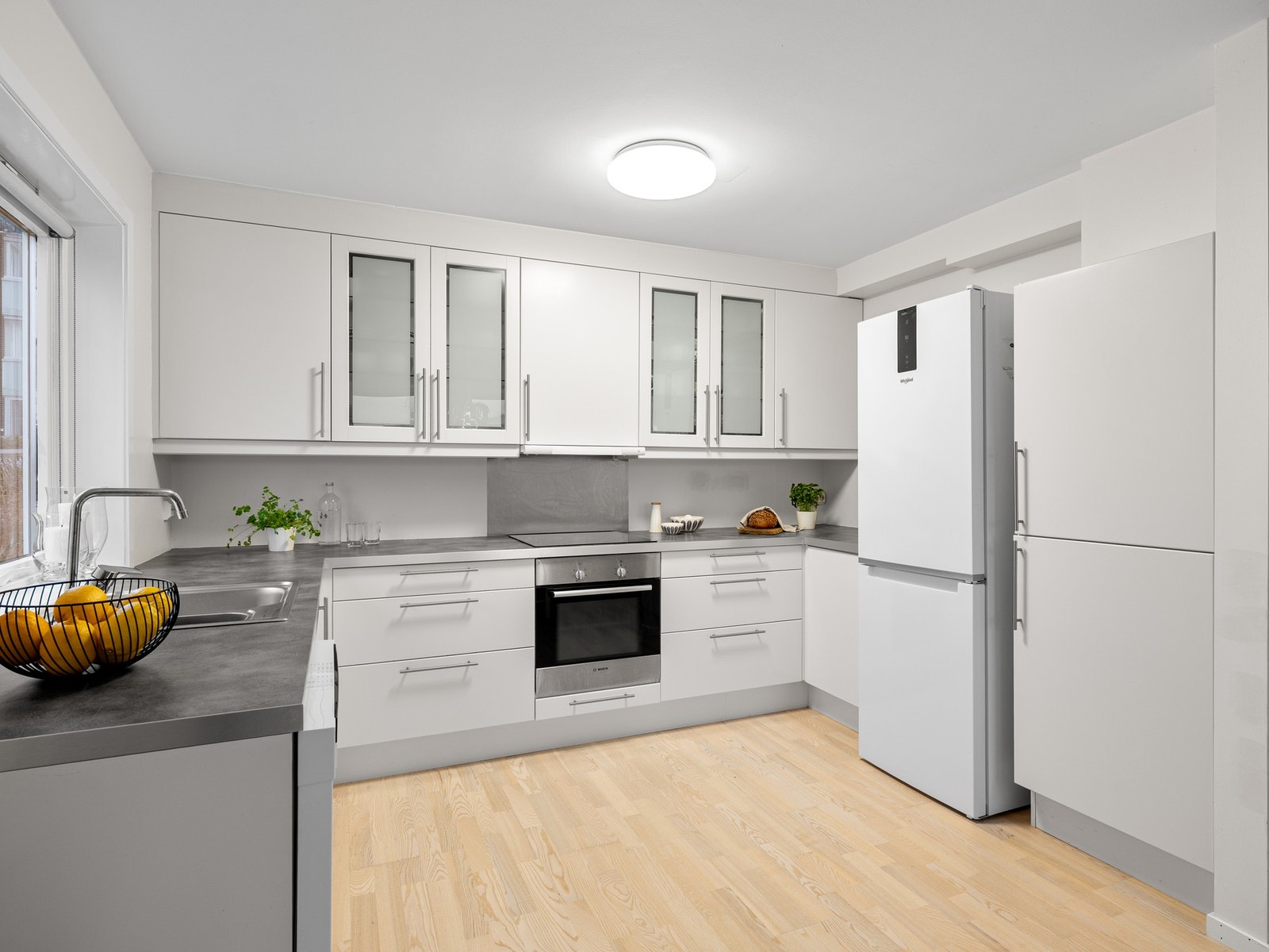 Kjøkkenet har et moderne uttrykk med slette fronter og benkeplate i laminat Galleribilde