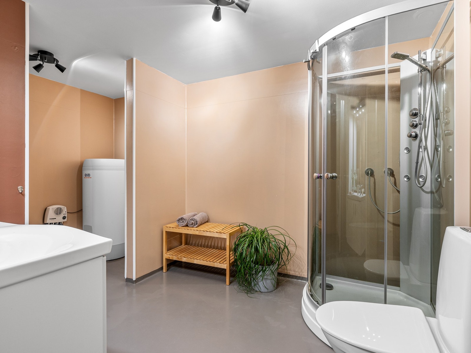 Rommet er utstyrt med både servantskap og høyskap som gir gode oppbevaringsmuligheter, samt dusjkabinett og toalett. Galleribilde