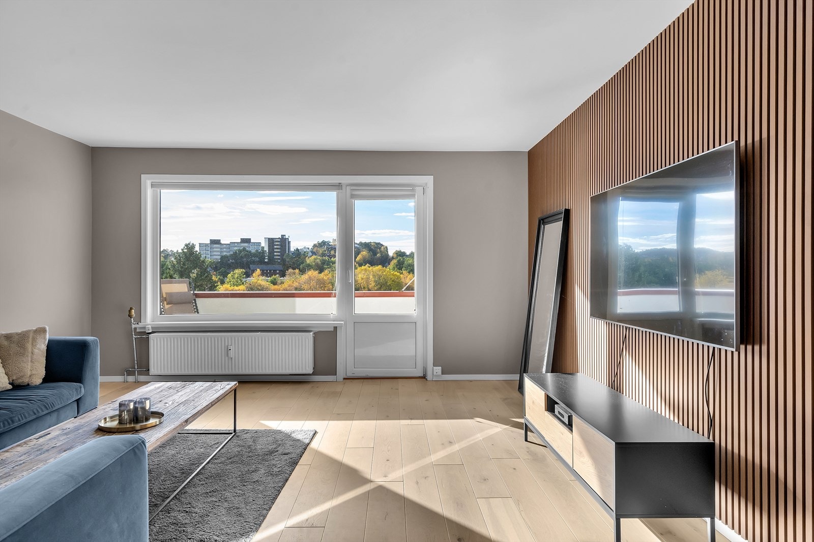 De store vindusflatene slipper inn rikelig med naturlig lys, som skaper en luftig og behagelig atmosfære. Stuen har i tillegg sentralvarme via radiator og har utgang til en solrik balkong Galleribilde