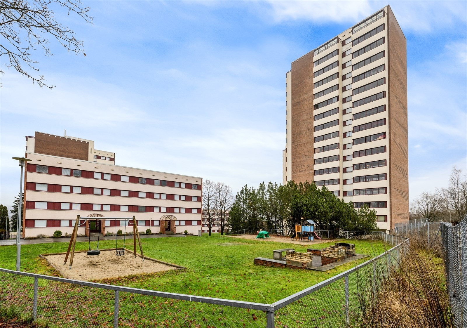 Fasadebilde som viser lekeplass og felles utearealer. Galleribilde