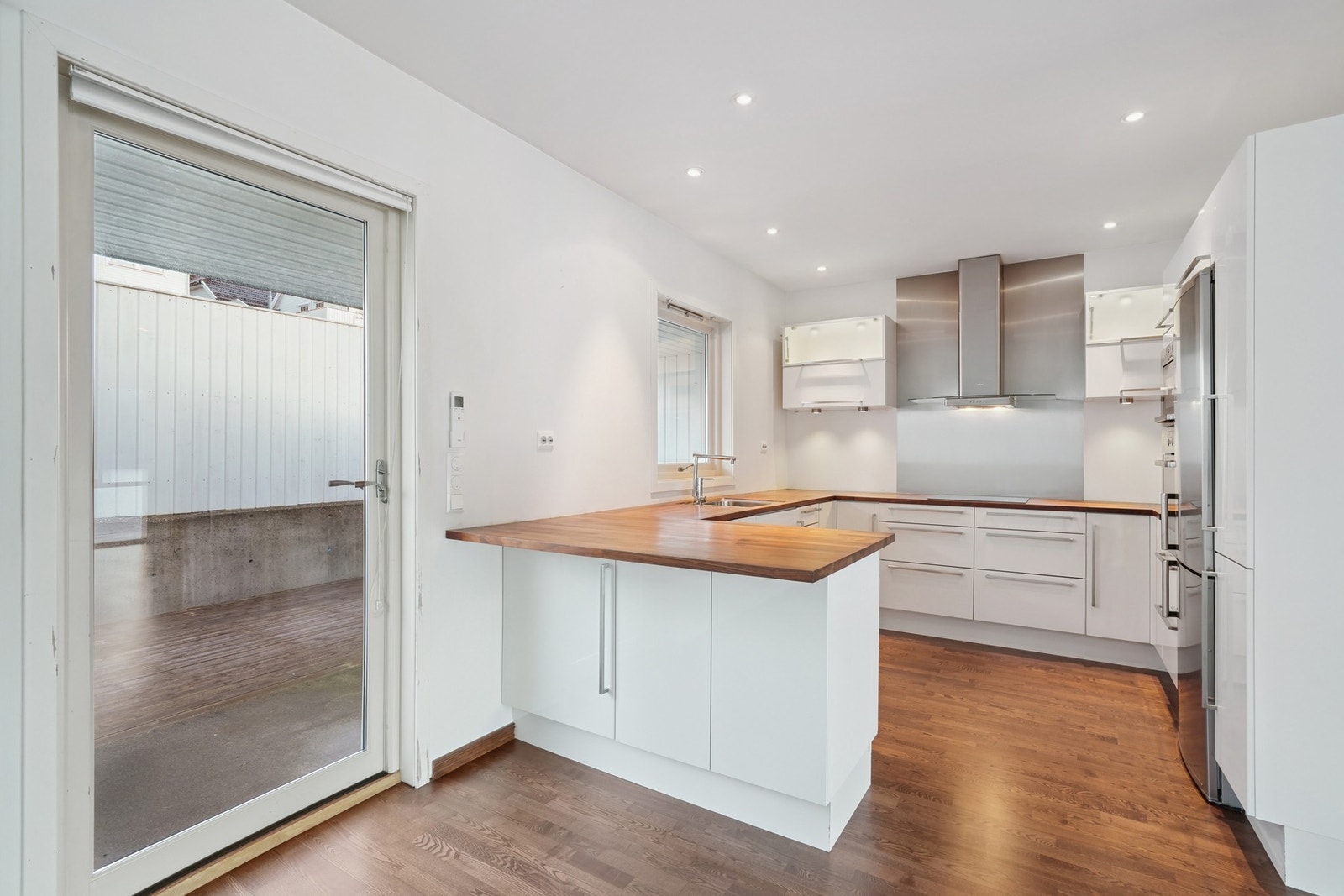 Lyst og pent kjøkken. Ledspotter i himling. Praktisk kjøkkenhalvøy og gode arbeidsflater for matlagning. Galleribilde