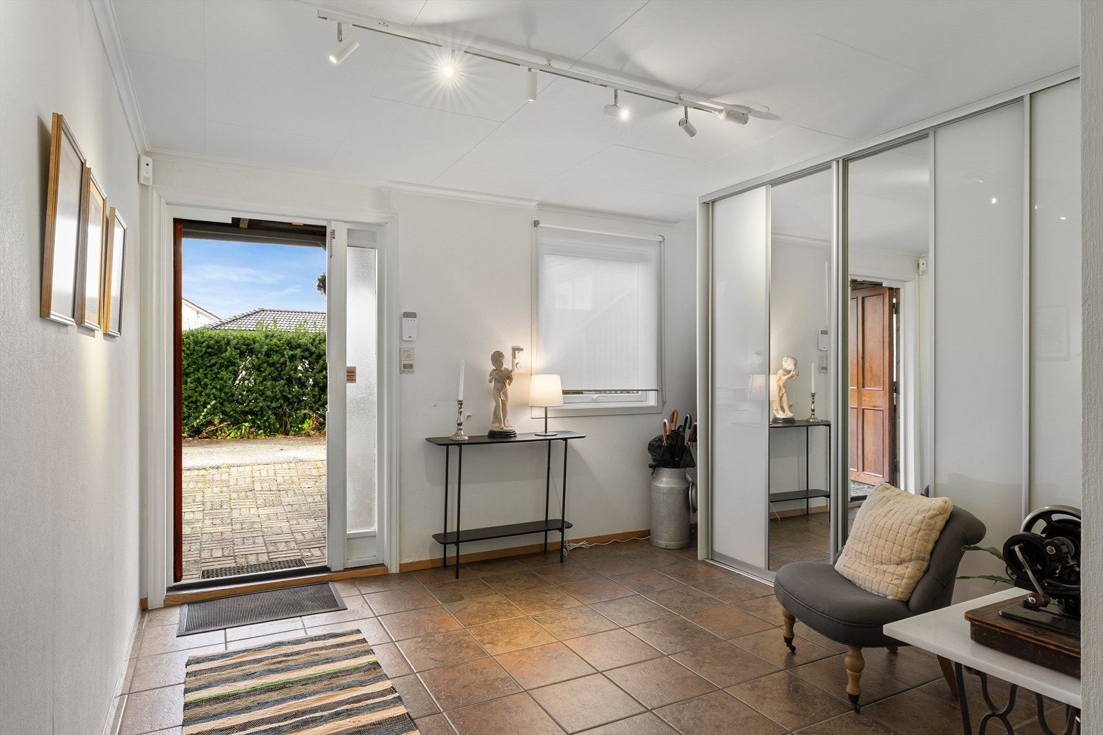 Romslig hall med fliser på gulv, gulvvarme og skyvedørsgarderobe. Galleribilde