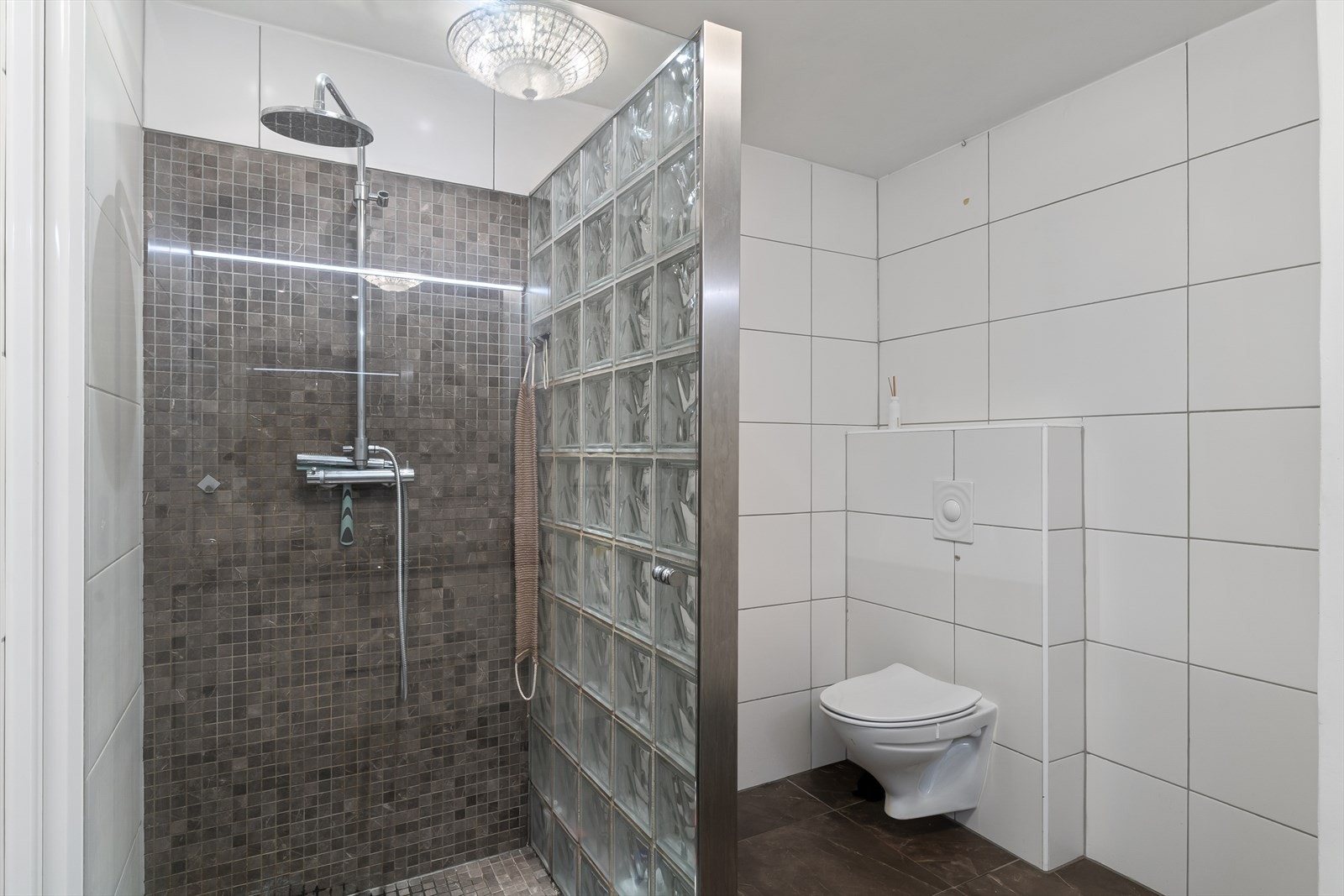 Moderne helfliset bad, med dusjnisje, vegghengt wc, og vask i møbel. Skyvedør inn til separat vaskerom. Badet er oppusset i 2009 av fagfolk. Galleribilde