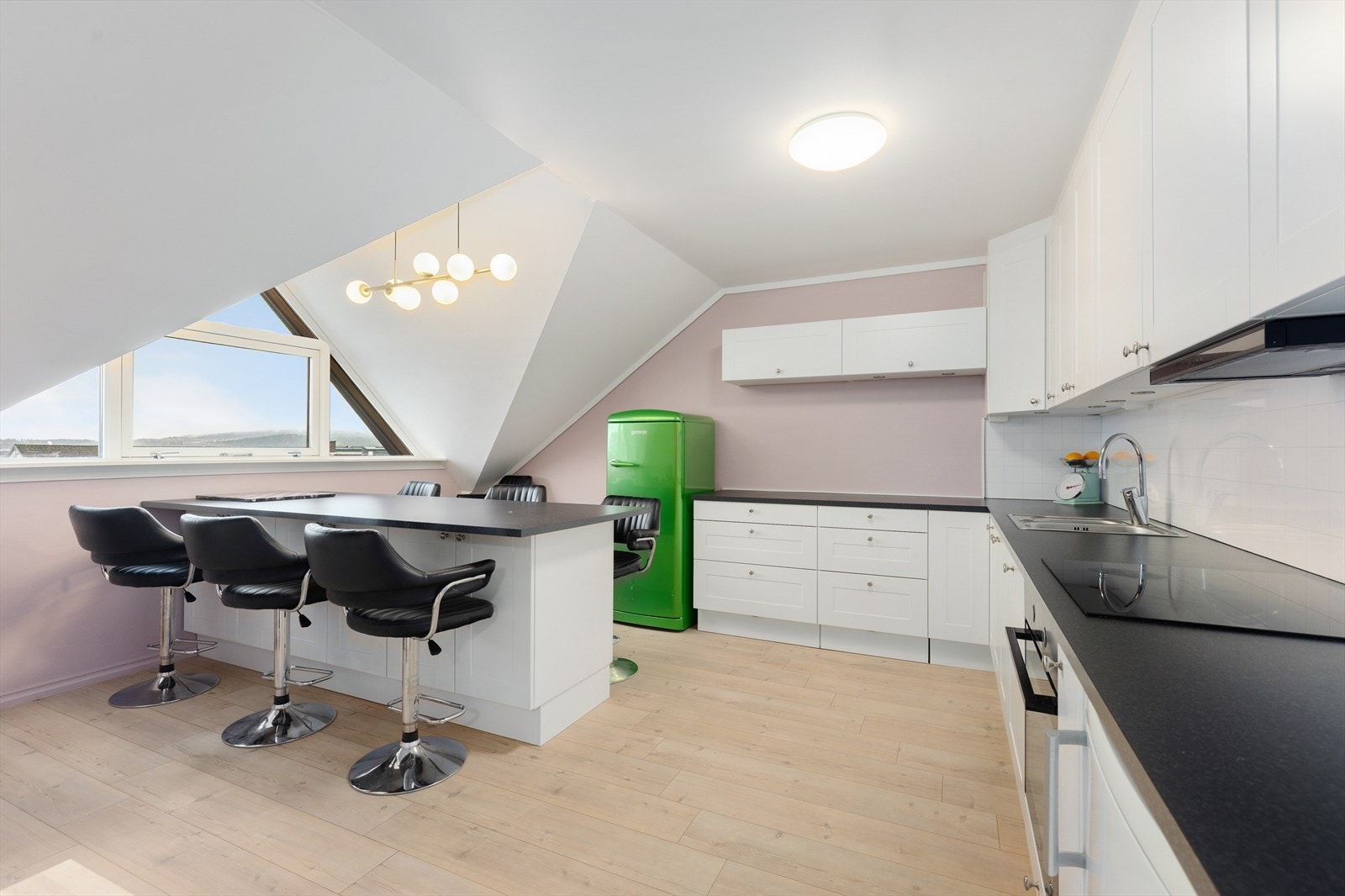 Kjøkkenet som ligger inntil stuen er pusset opp i 2017, med ny innredning og moderne laminat på gulvet. Her er det etablert en stor kjøkkenøy ved vinduet, med mange sitteplasser og oppbevaringsplass på den ene siden Galleribilde