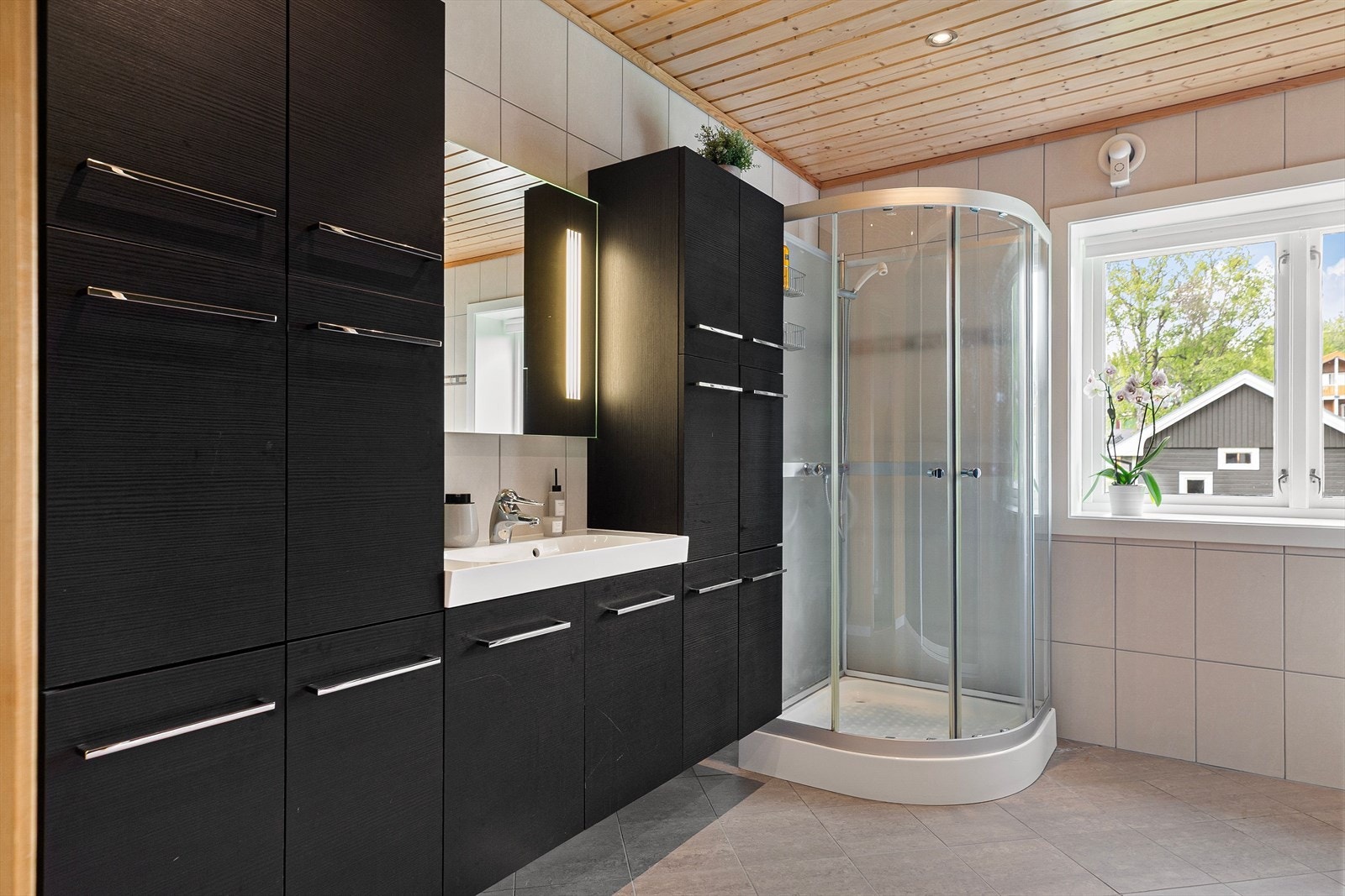 Baderomsinnredningen gir god plass til oppbevaring av håndklær og hygieneartikler. Galleribilde