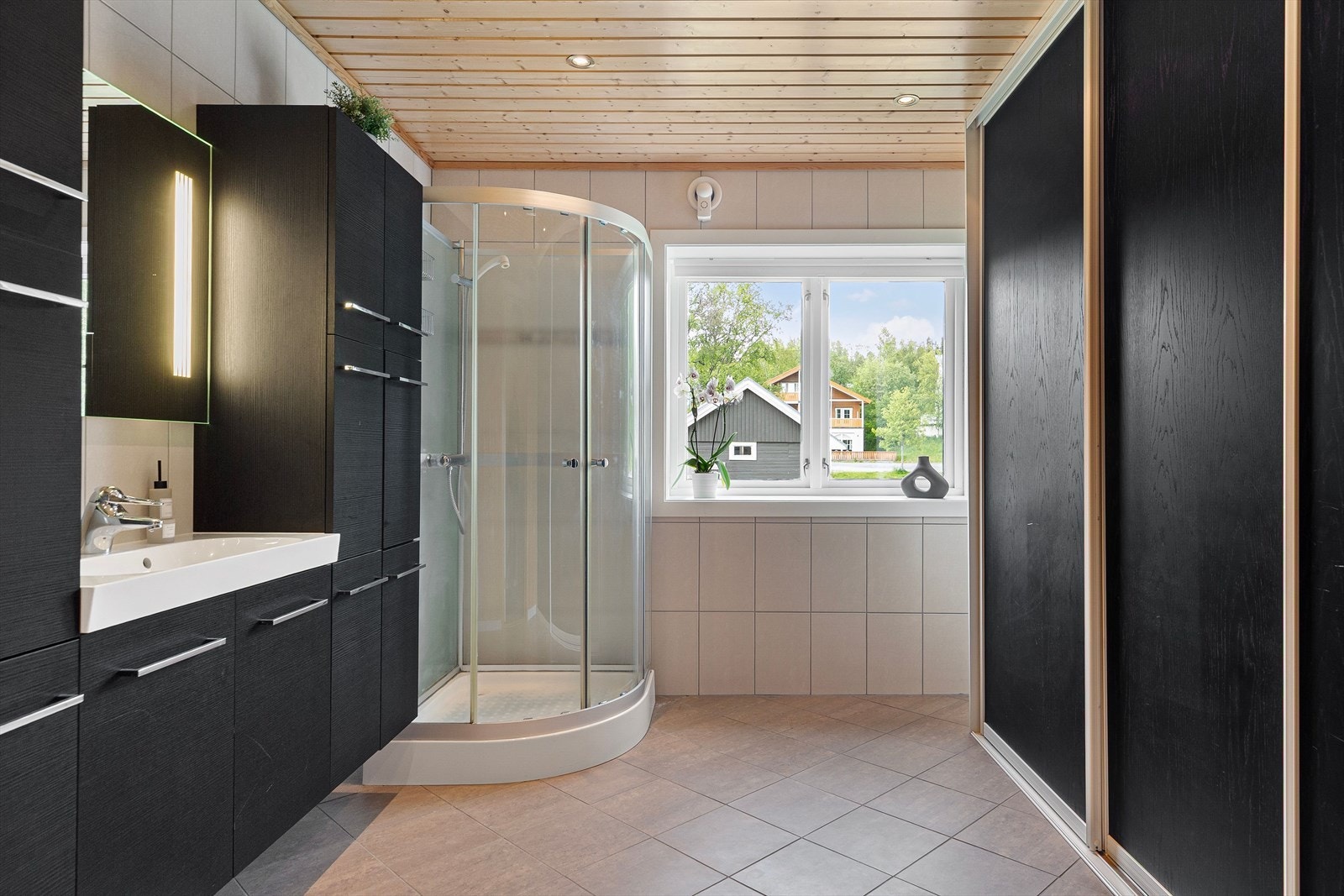 Badet nede har gulvvarme, dusjkabinett og stor skyvedørsgarderobe. Galleribilde