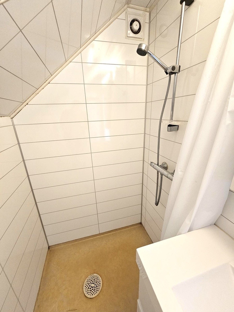 Skråtak i dusj kommer ikke i veien for å stå normalt i dusjen Galleribilde