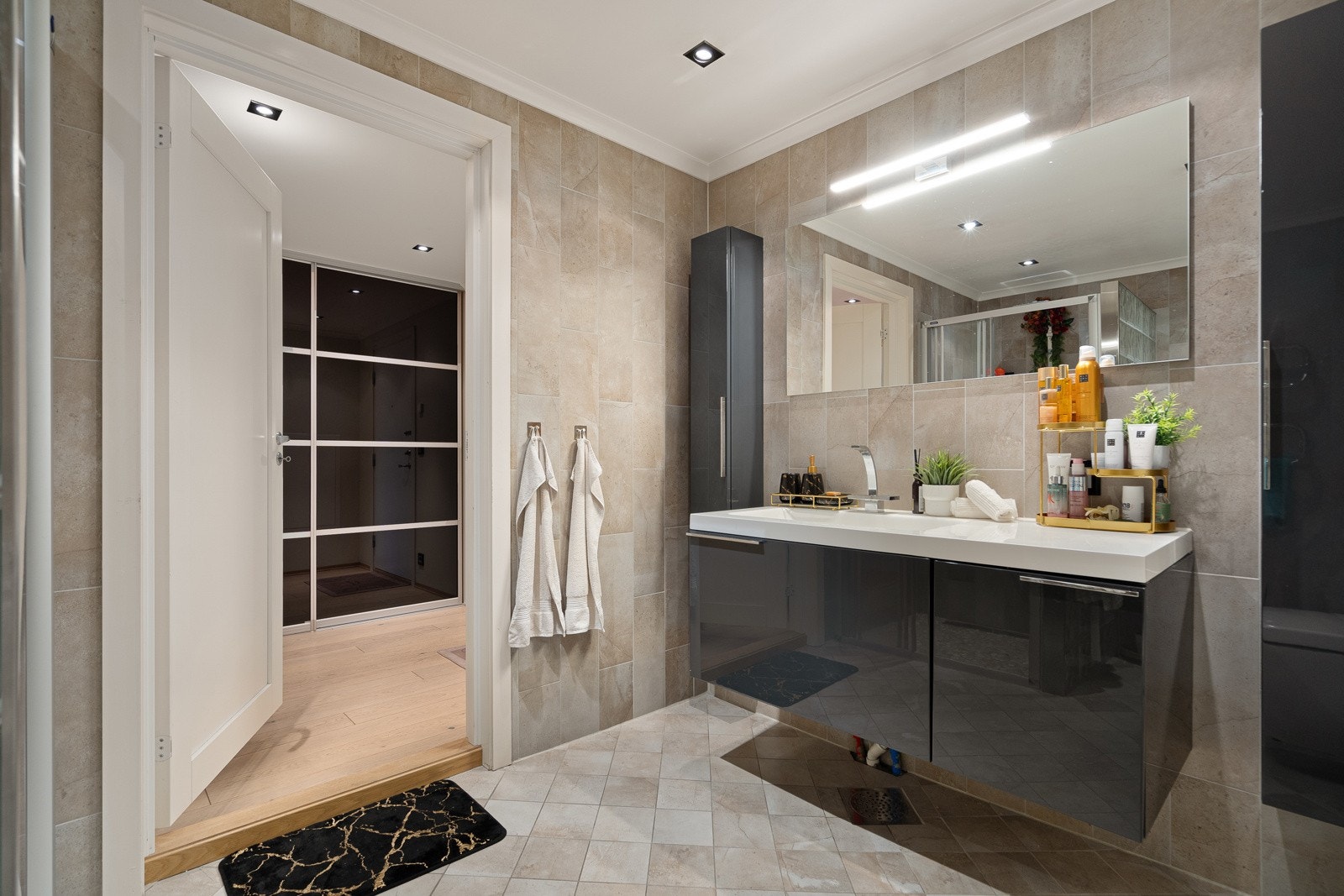 Badet har servant med underliggende skap, dusj og opplegg til vaskemaskin Galleribilde