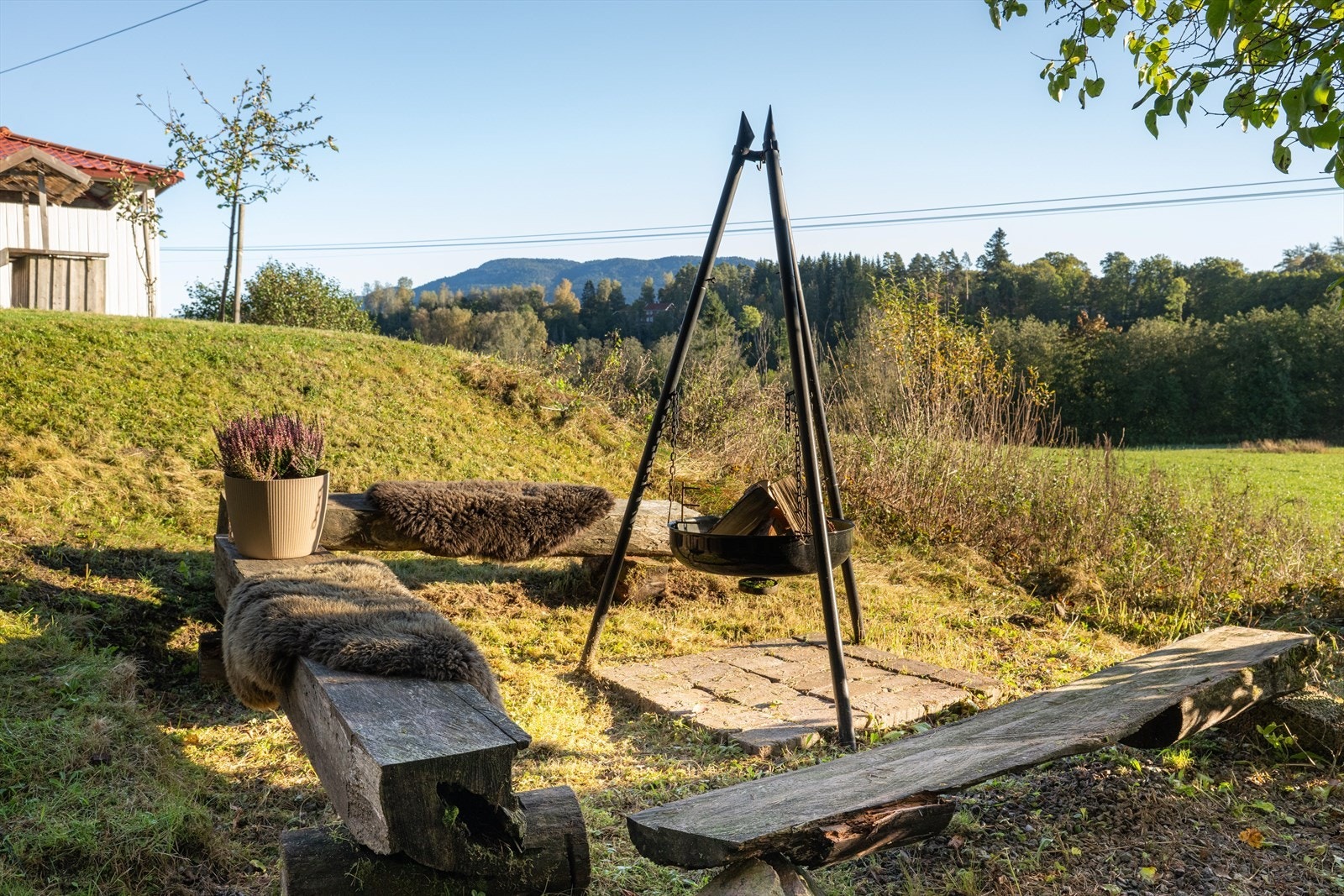I hagen er det opparbeid en hyggelig bålplass med sittebenker. Galleribilde