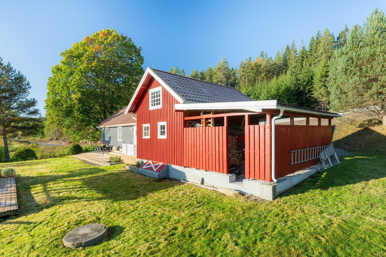 Det står garasje/ uthus på tomten som inneholder lagringsplass og bodrom mm., samt carport. Galleribilde
