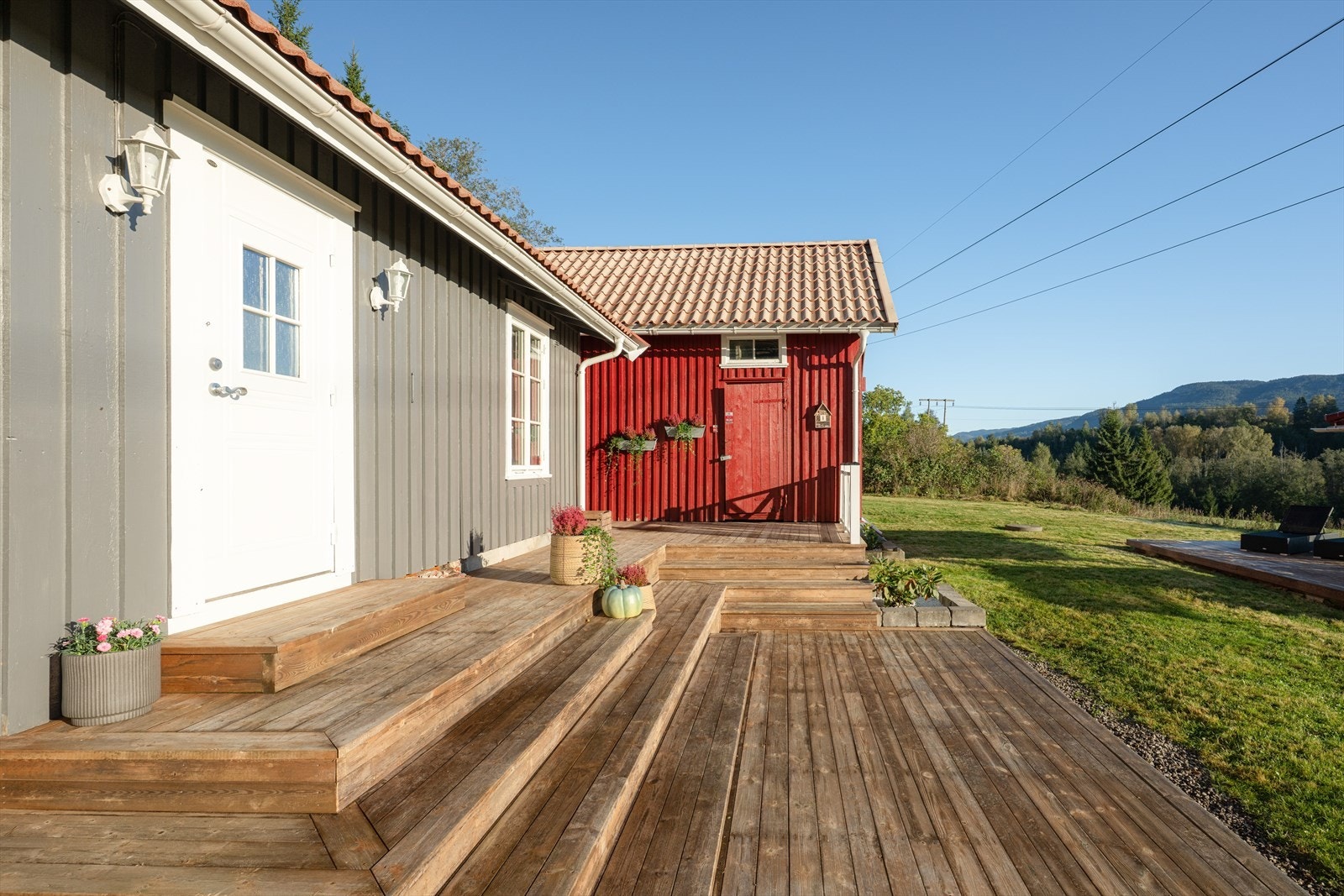 Eiendommens tomt ligger med fint utsyn over åpne kulturlandskap og elva, med flott skjermet hage Galleribilde