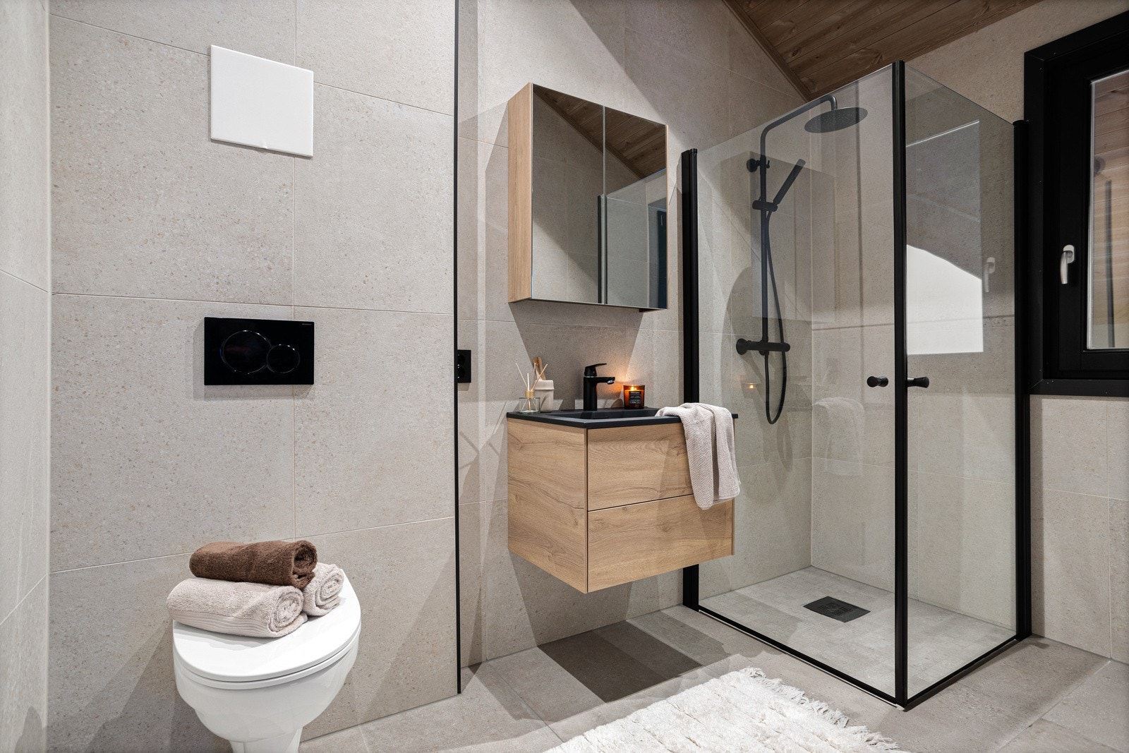 Pent og romslig bad med moderne innredning. Rommet inneholder servant i innredning, dusjnisje og vegghengt toalett Galleribilde