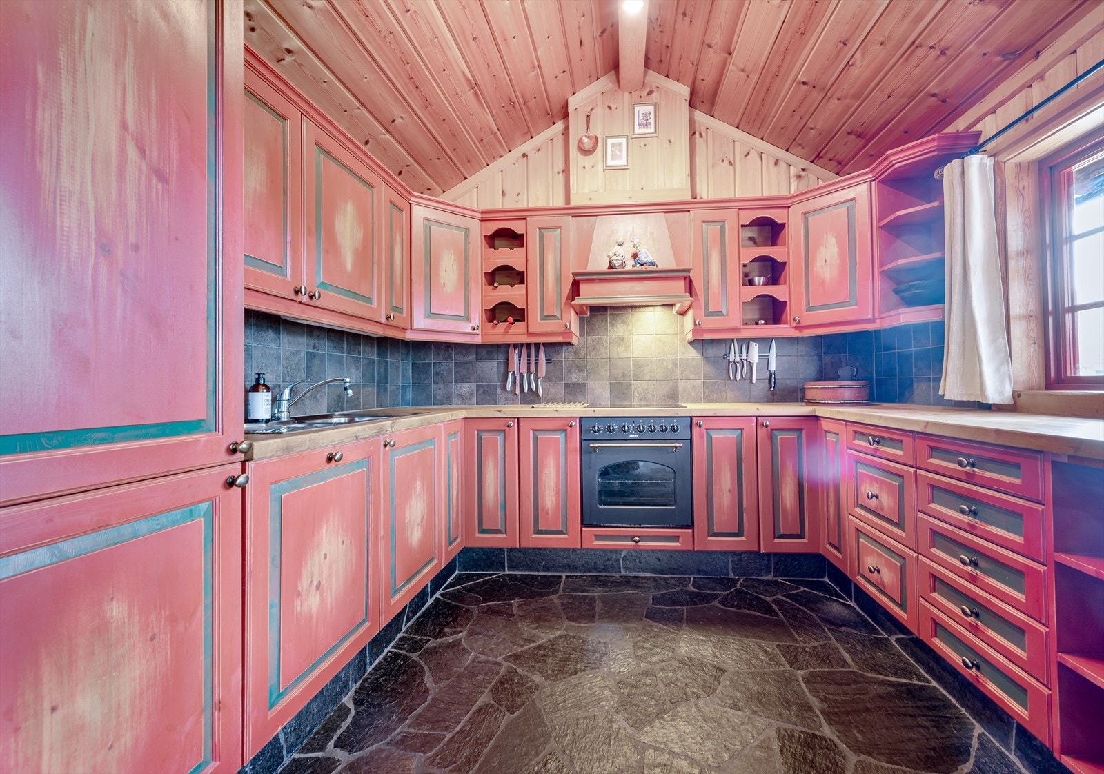 Kjøkkenet er av god størrelse med rikelig med skap- og benkeplass for matlaging og oppbevaring Galleribilde