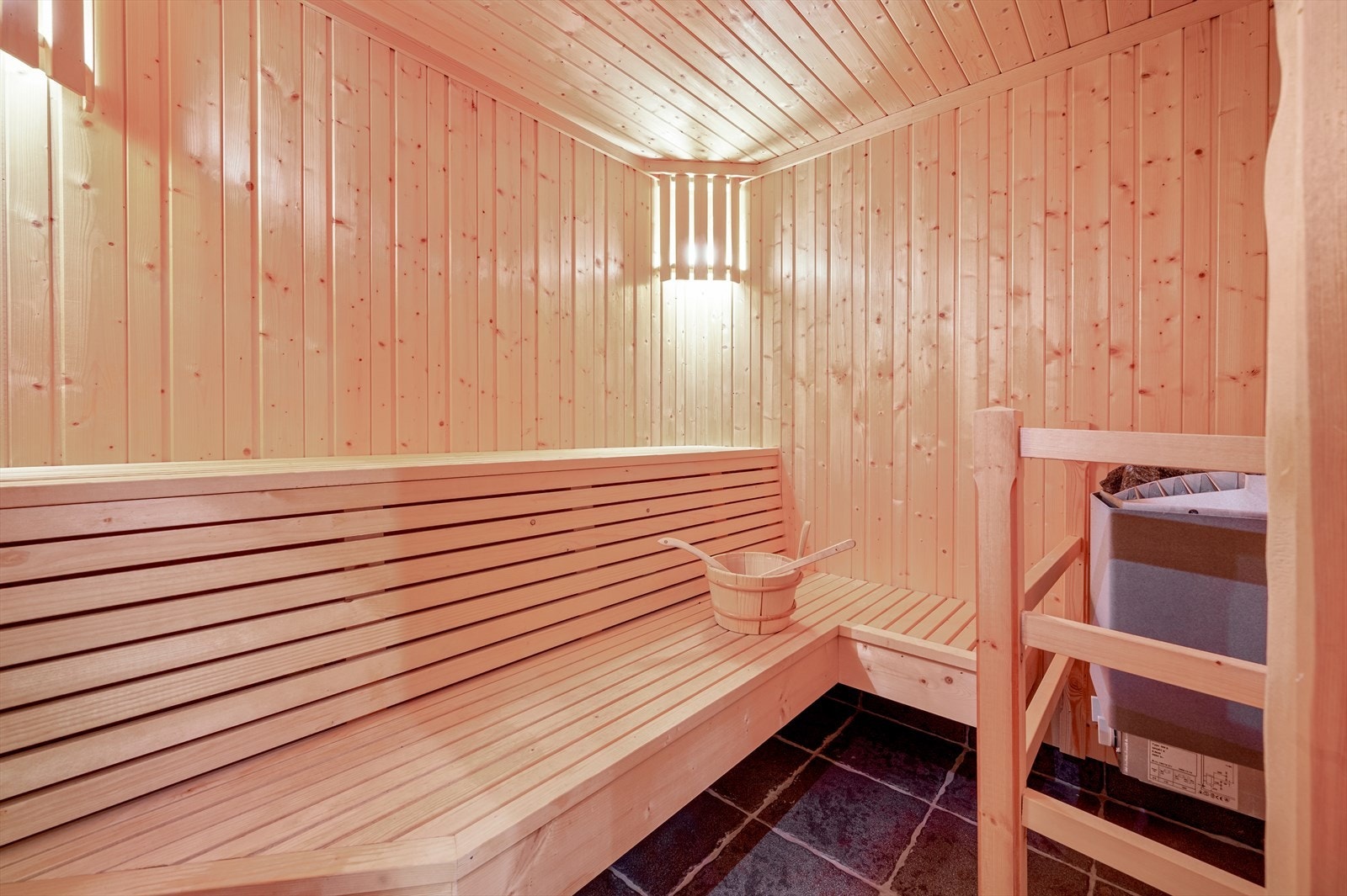 Flott badstue fra byggeår med sittebenker av tre. Rommet har fliser på gulv og trepanel på vegger og i tak Galleribilde