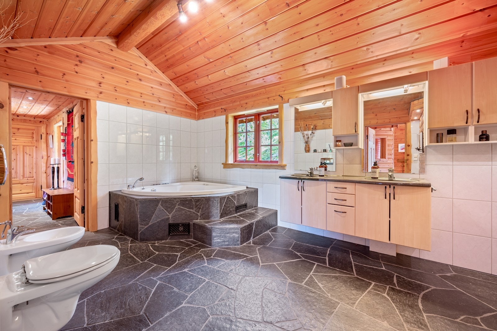 Romslig bad med boblebad, vegghengt toalett og bidet, dusjhjørne og badstue Galleribilde