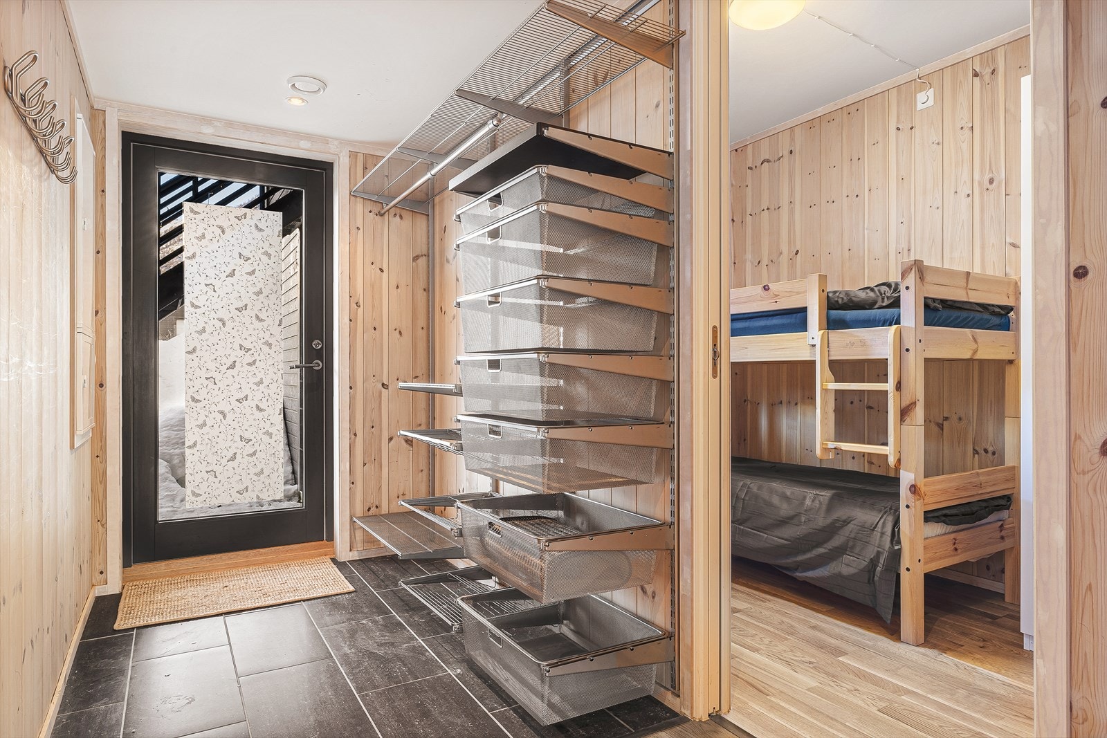 Inngangen fører inn til en koselig entré med flislagt gulv, med god plass til å henge fra seg yttertøy og sette fra seg sko Galleribilde