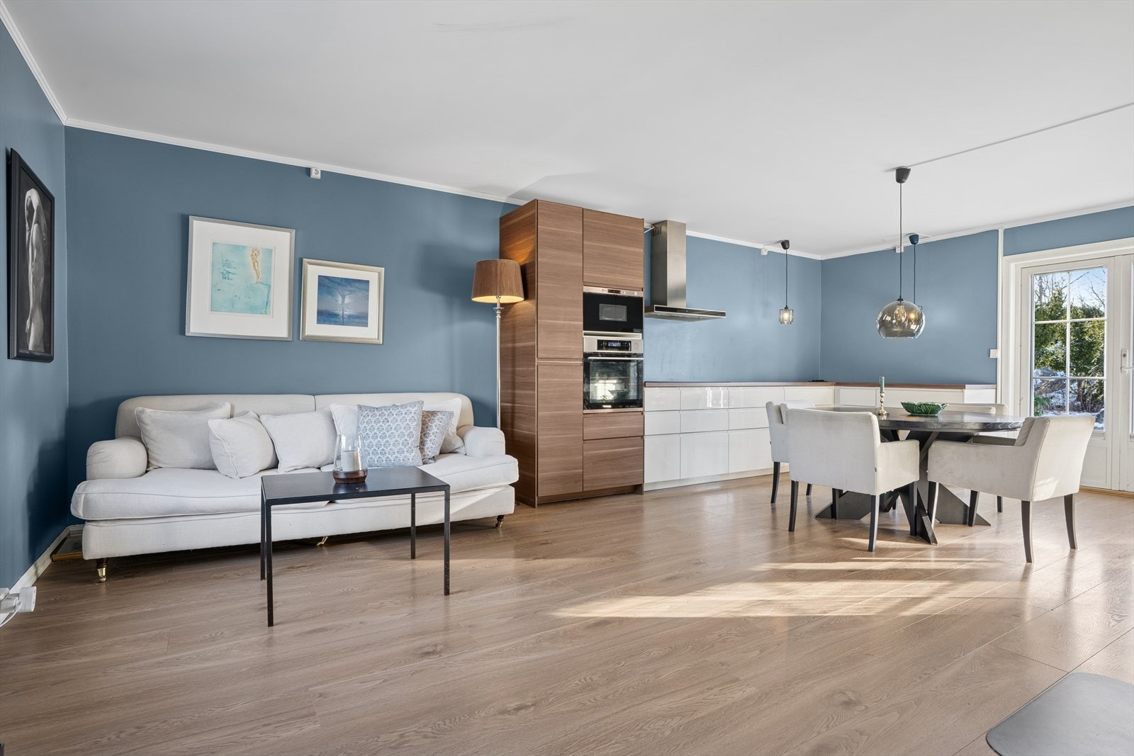 Romslig og luftig stue i åpen løsning til et moderne kjøkken. Galleribilde