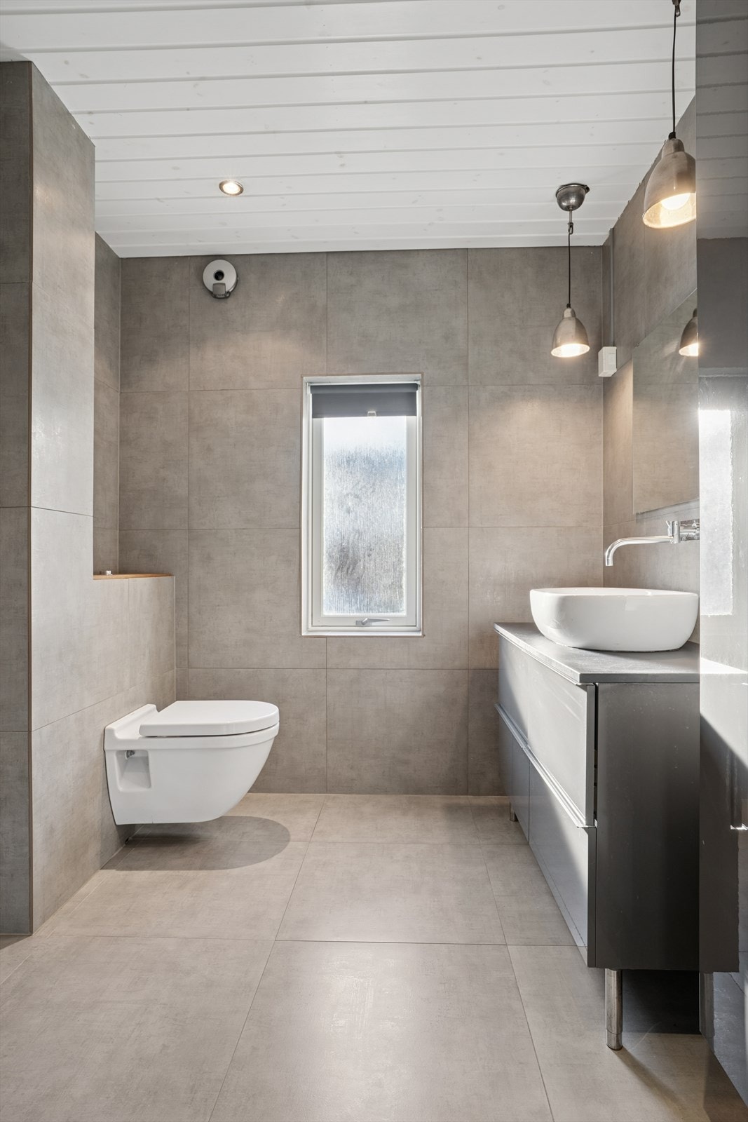 Badet er utstyrt med innredning med glatte fronter, bolleservant, oppbevaring i skuffeseksjon, sideskap og speil over servanten. Galleribilde