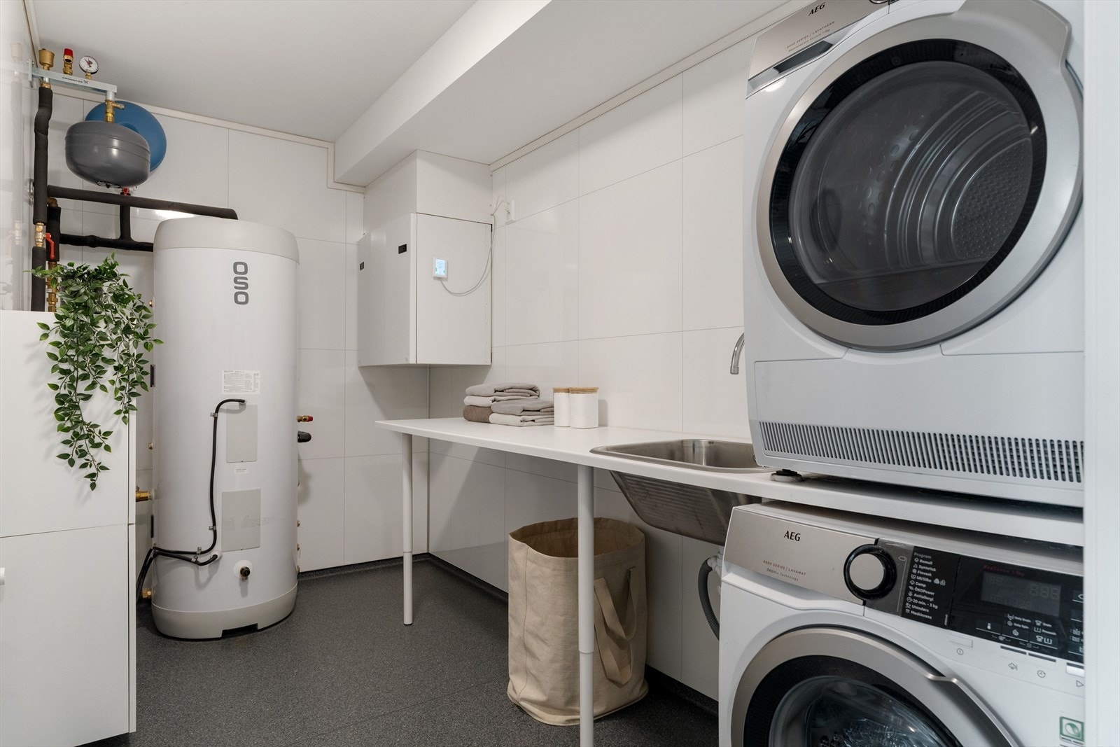 I underetasjen har boligen et eget vaskerom, med skyllekum, arbeidsbenk og varmtvannsbereder. Galleribilde