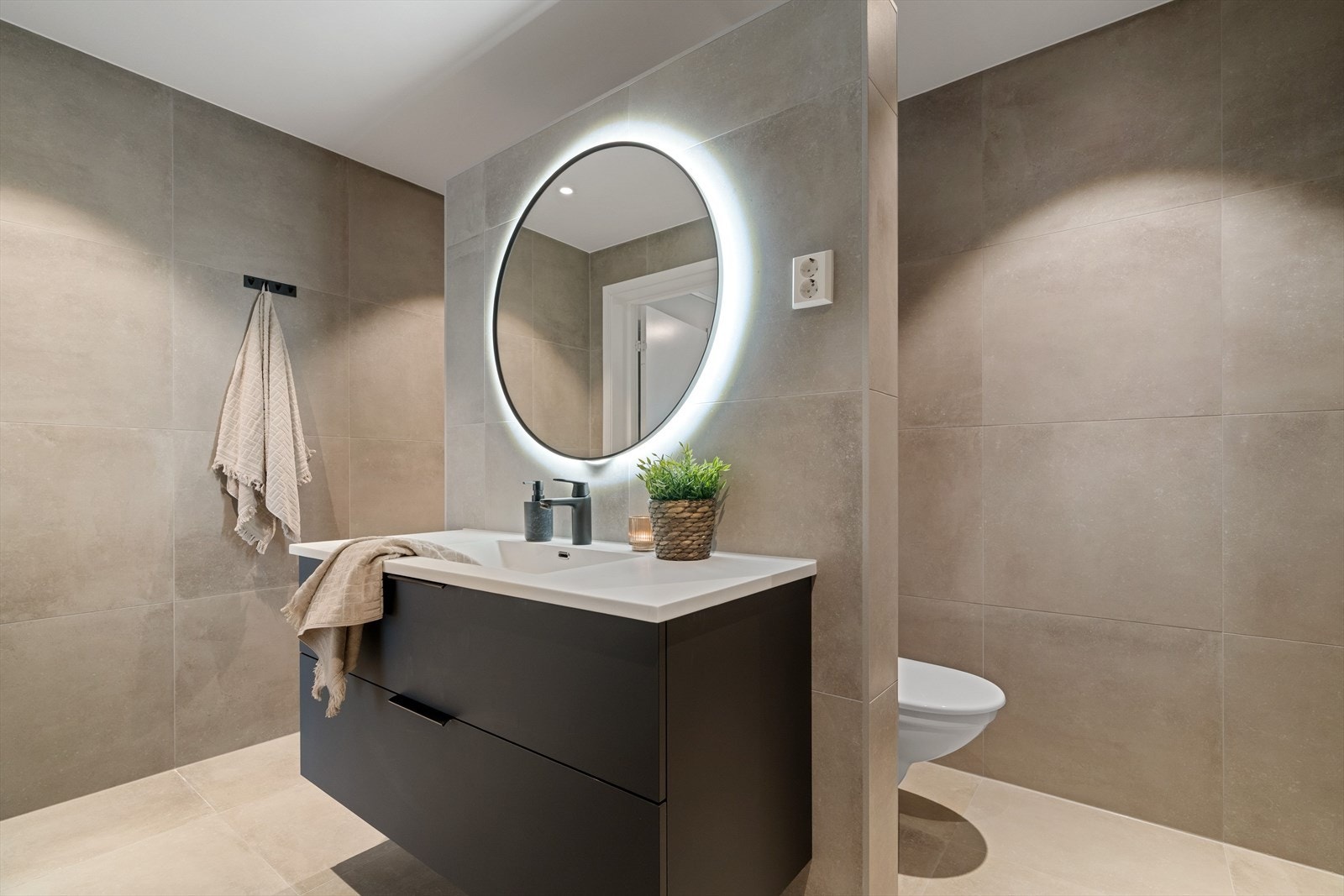 Gulvvarme er installert, og badet har en moderne innredning med stilig speil. Galleribilde