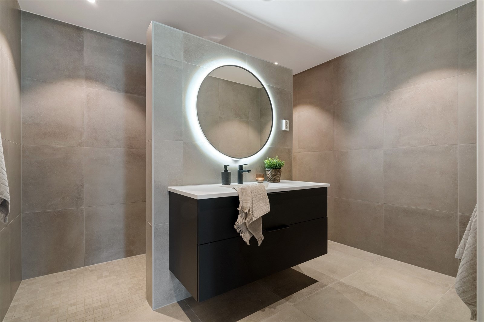 Dagene får en fin start på et stort bad i underetasjen, der ulike soner inkluderer en egen nisje med vegghengt toalett. Galleribilde