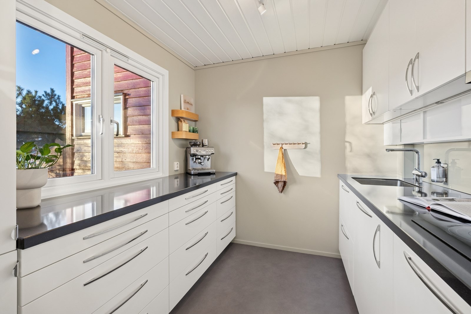 Kjøkkeninnredning fra 2015 med glatte fronter og benkeplater i steinkompositt. Godt med skap- og benkeplass som gjør kjøkkenet praktisk til daglig bruk. Galleribilde