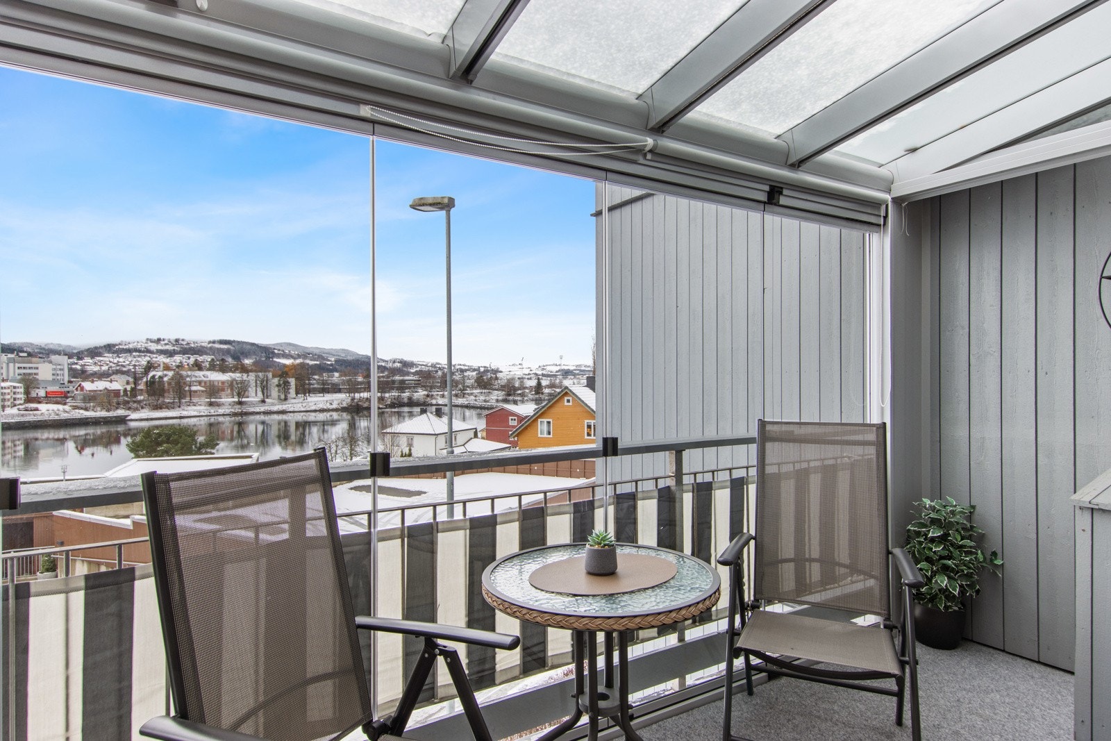 Den innglassede balkongen kan enkelt åpnes opp på varme dager. Glassfeltene skyves til siden, slik at du kan få inn frisk luft. Galleribilde