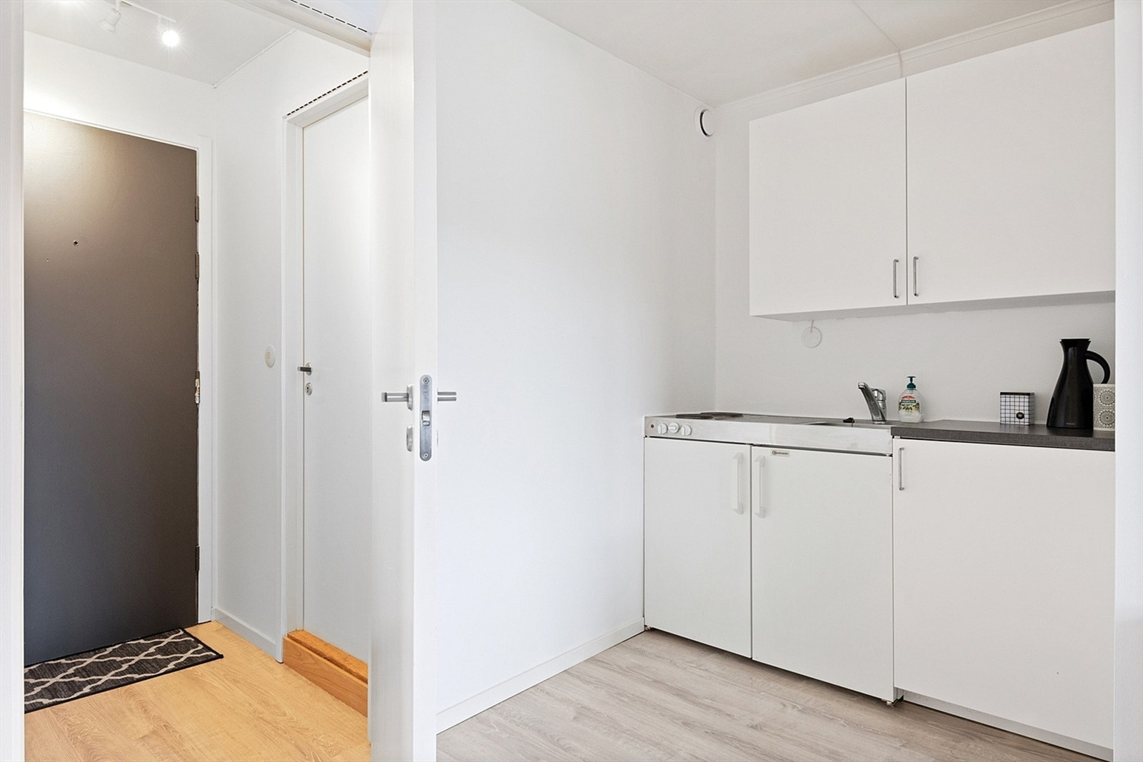 Kjøkkenet ligger i delvis åpning til stuen og har innredning med slette fronter. Benkeplate i laminat med oppvaskkum i stål. Ved oppvaskkummen er det stålplate med to koketopper og kjøleskap. Galleribilde