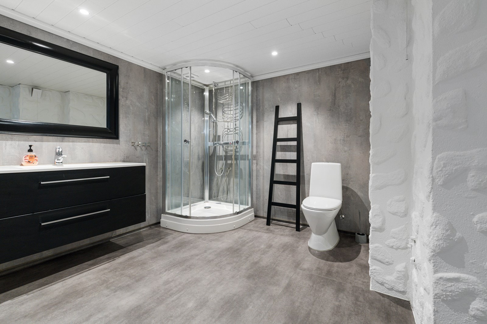 Bad/vaskerom i kjelleretasjen har vinylbelegg på gulv og våtromsplater på vegger | rommet er utstyrt med baderomsinnredning, wc, dusjvegger og opplegg for vaskemaskin og tørketrommel Galleribilde