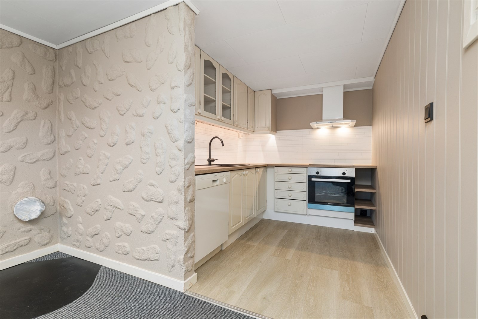 Kjøkken i kjelleretasjen med profilerte, malte skapfronter og med glass | benkeplater av laminat med nedfelt vask | utsparing for komfyr, oppvaskmaskin og plass til kjøle-/fryseskap Galleribilde