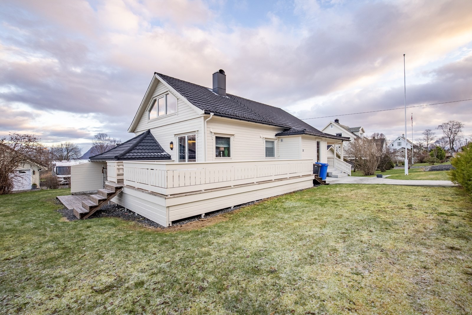 Flat tomt på 956,6 m² er opparbeidet med bl.a. treterrasse, veranda, singelbed, plen og beplanting Galleribilde